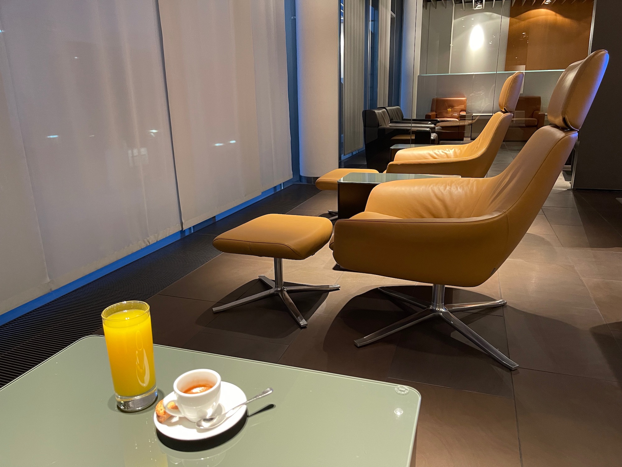 a coffee cup and a glass of juice on a table in a room