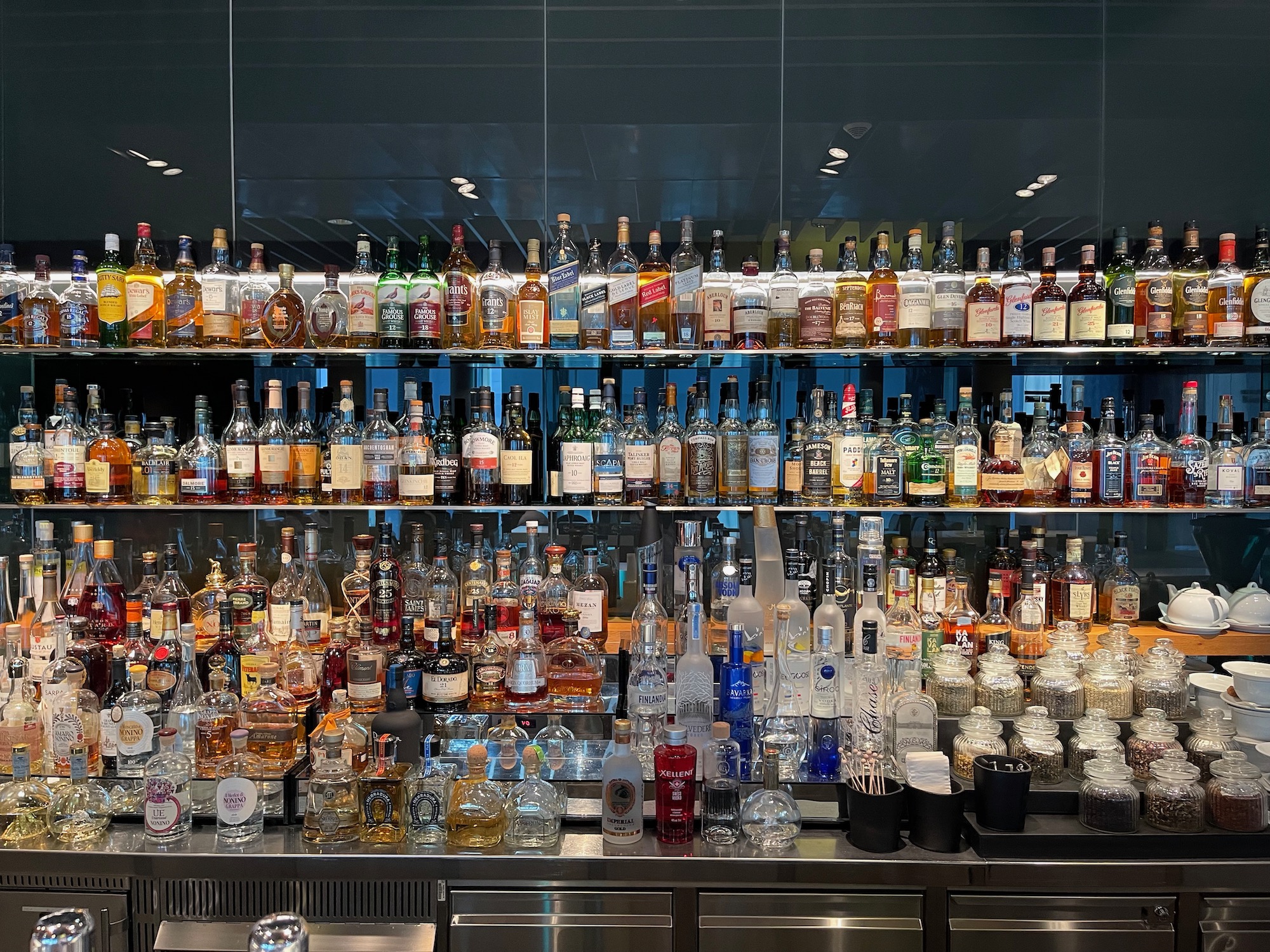 a large group of bottles of alcohol on a shelf
