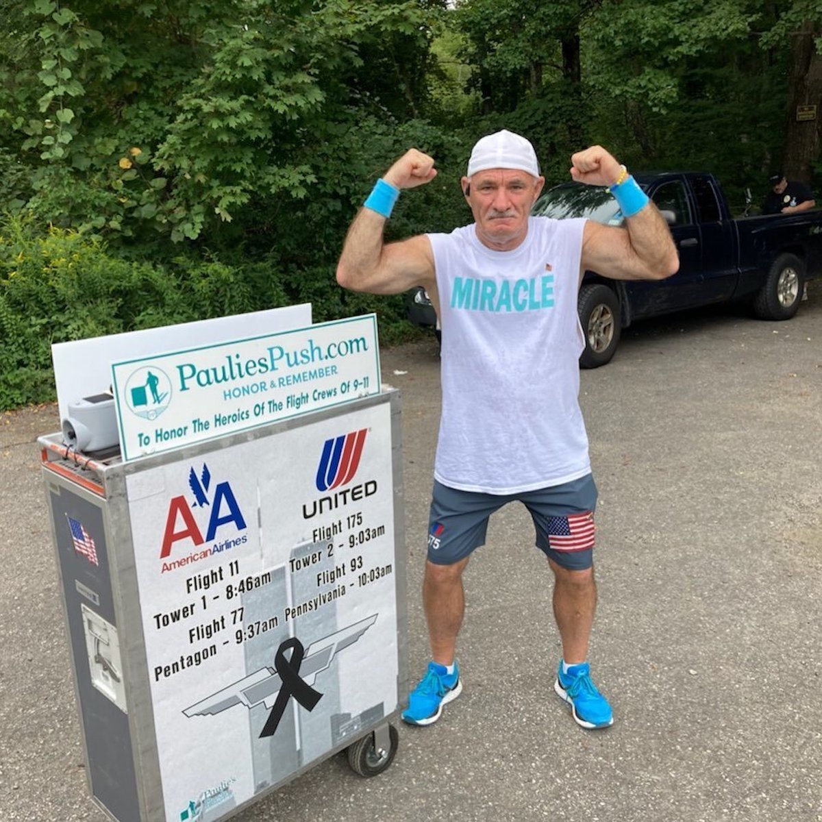 a man flexing his muscles in front of a cart