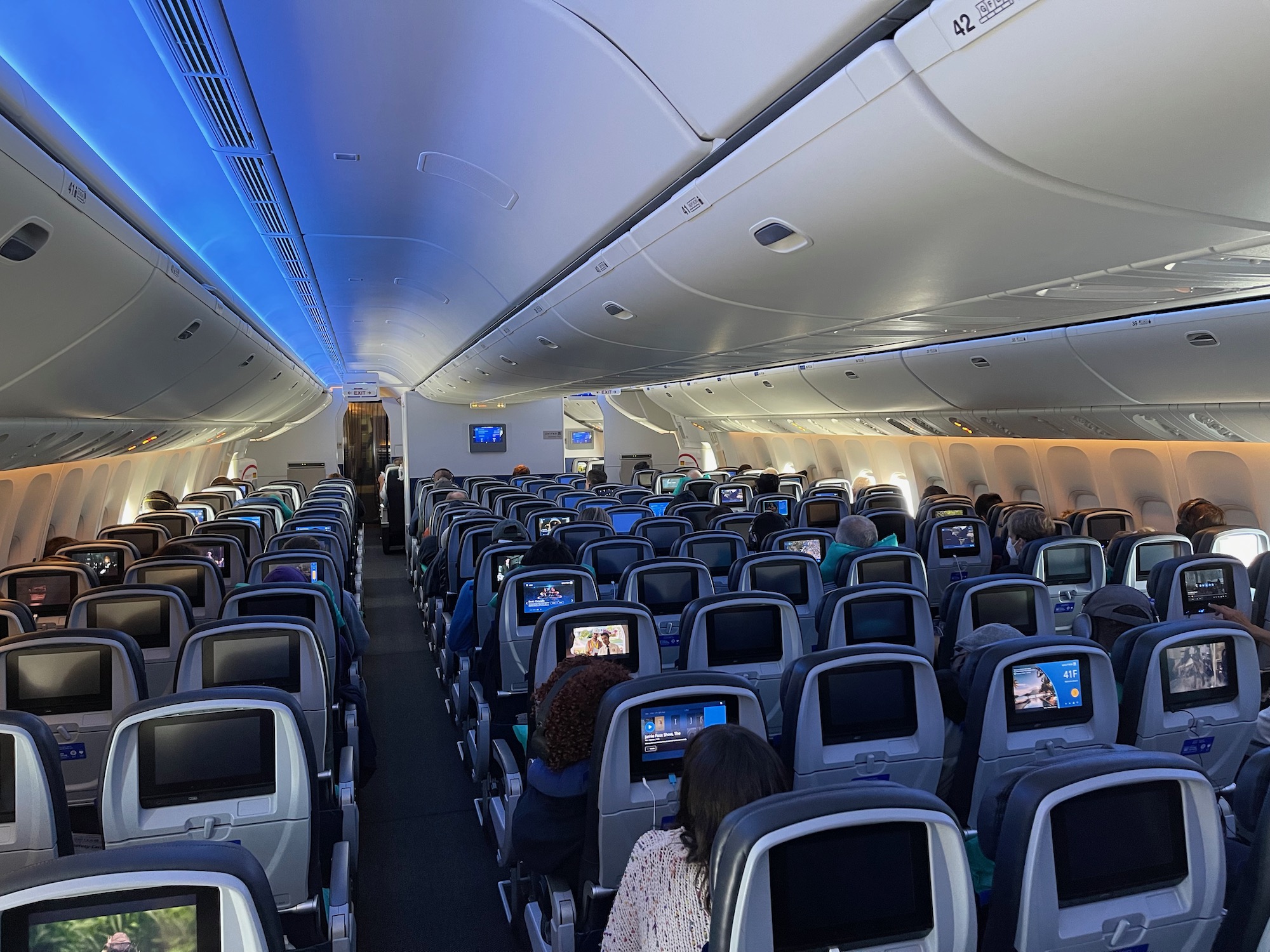 an airplane with many seats and a few people sitting in the seats