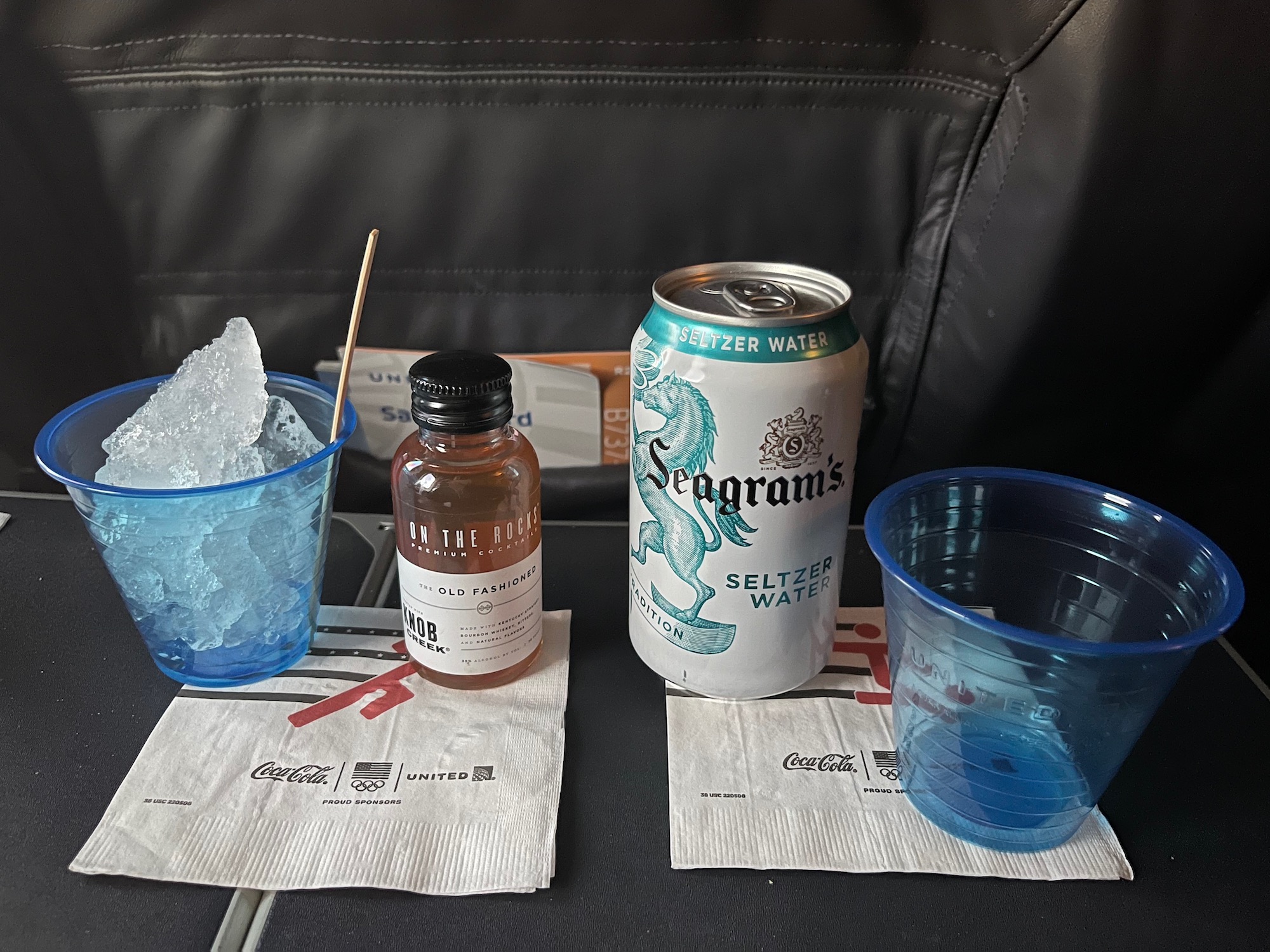 a can of soda and cups on a table