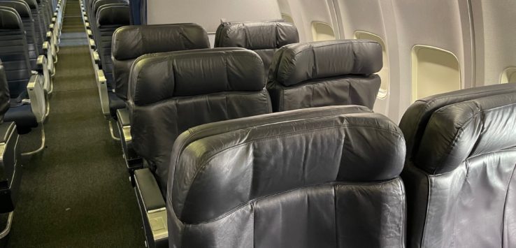 a row of black leather seats in an airplane