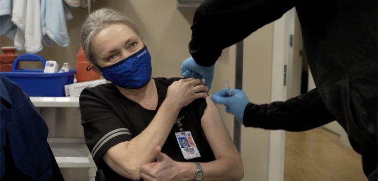 a woman wearing a mask and giving a thumbs up