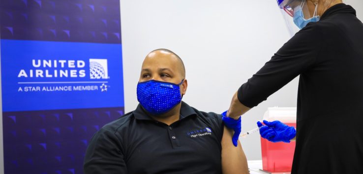 a person in a mask getting a vaccine shot