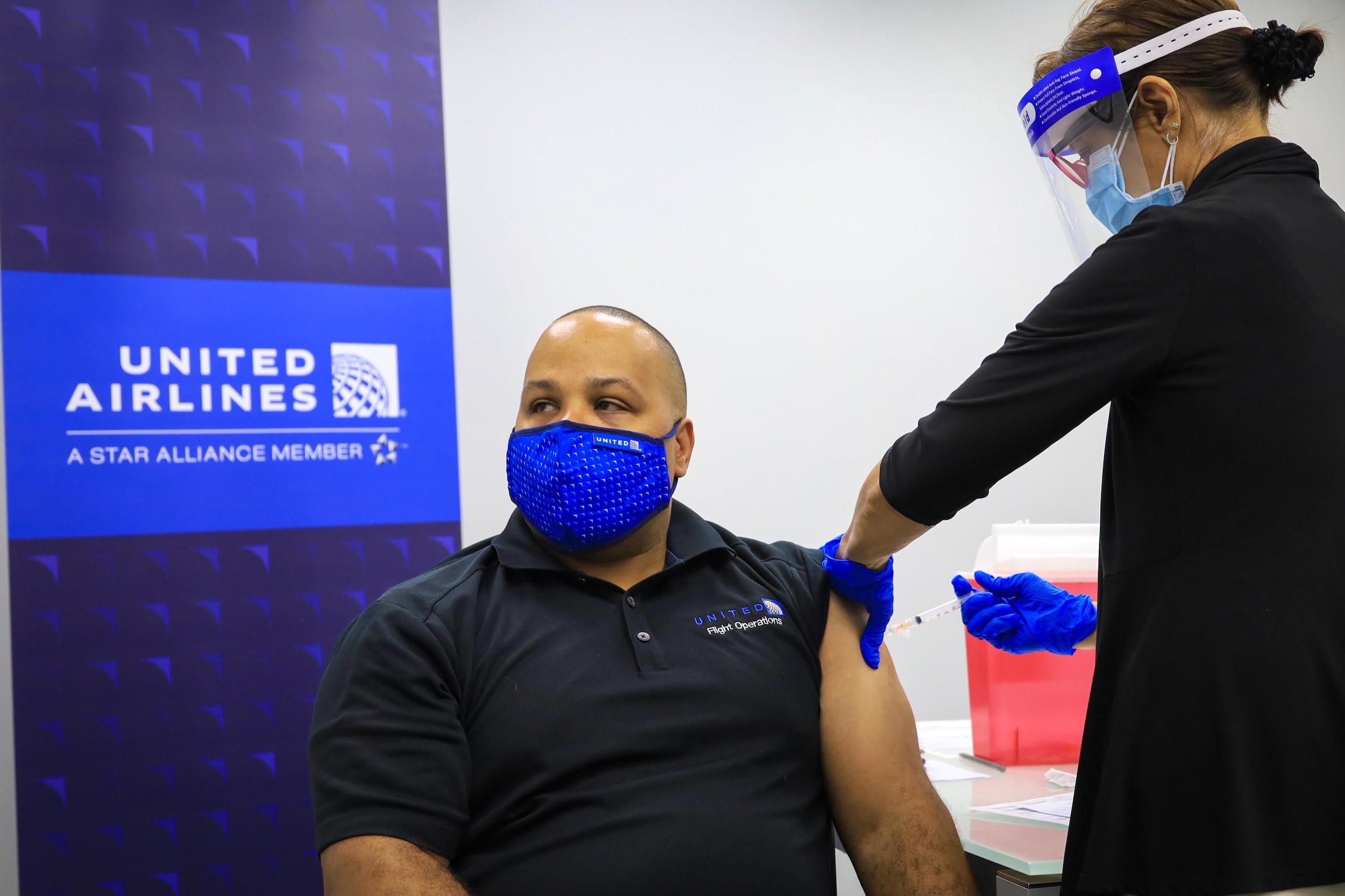 a person in a mask getting a vaccine shot