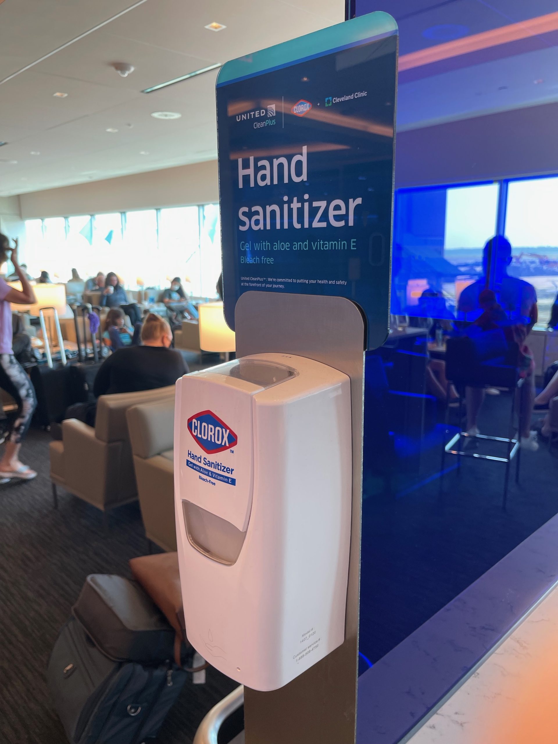 a hand sanitizer dispenser in a room with people