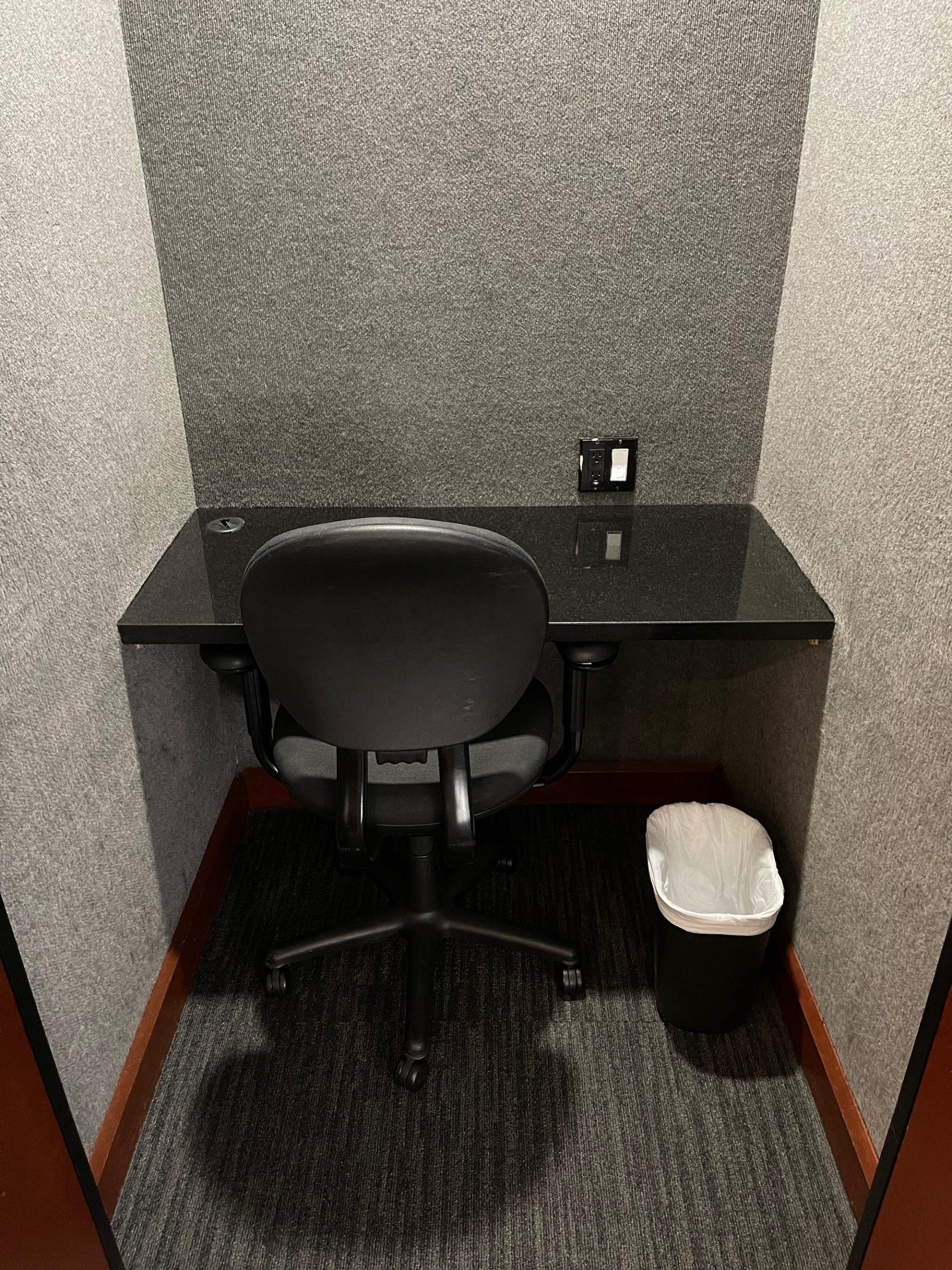 a chair and a trash can in a small office