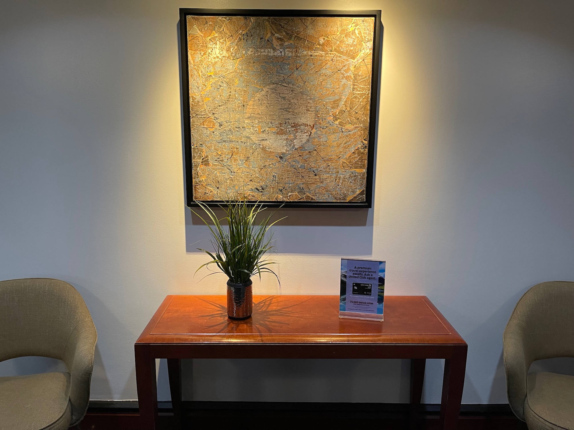 a table with a plant on it and a framed map on the wall