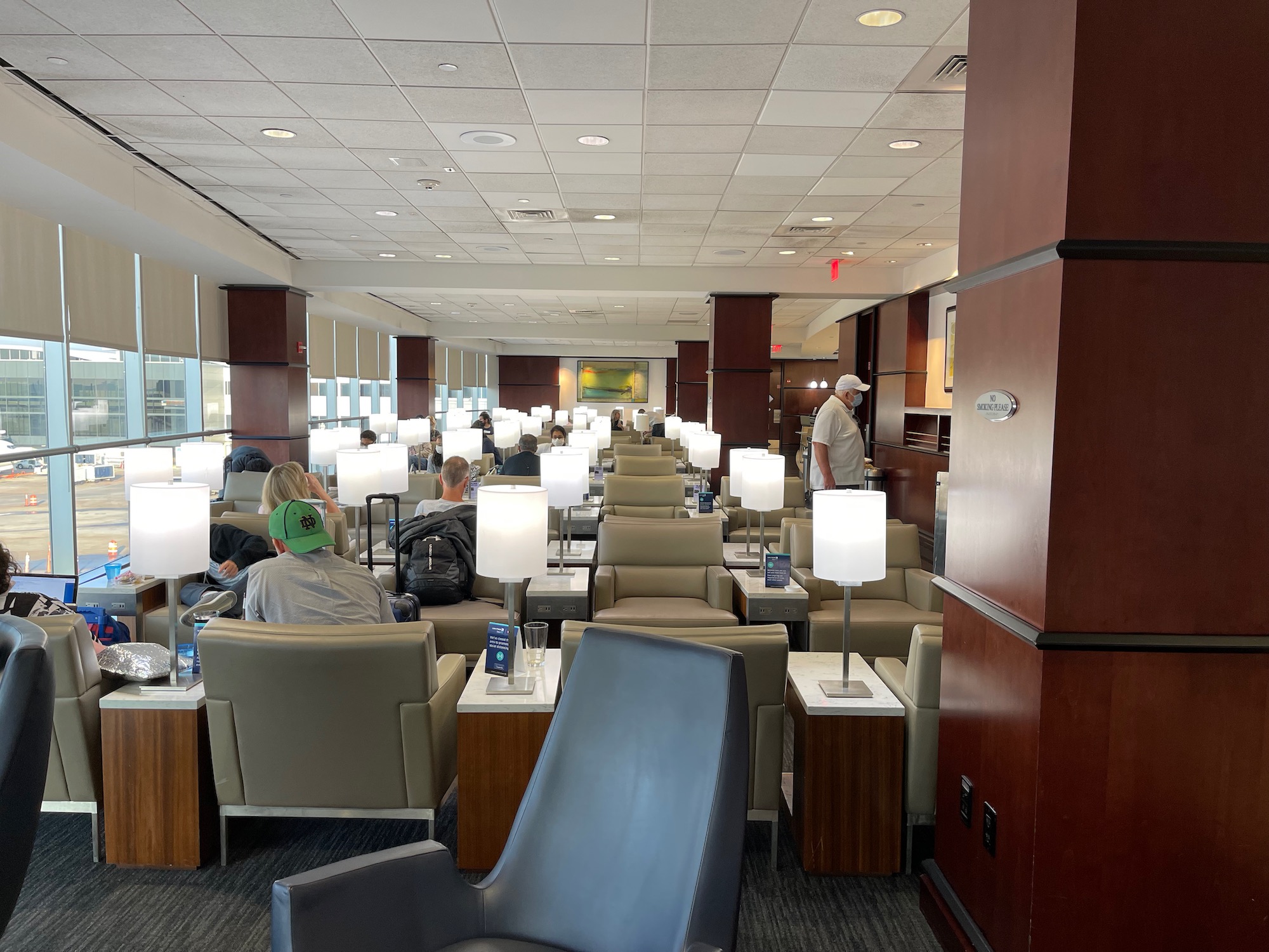 a group of people sitting in chairs in a room with white lamps