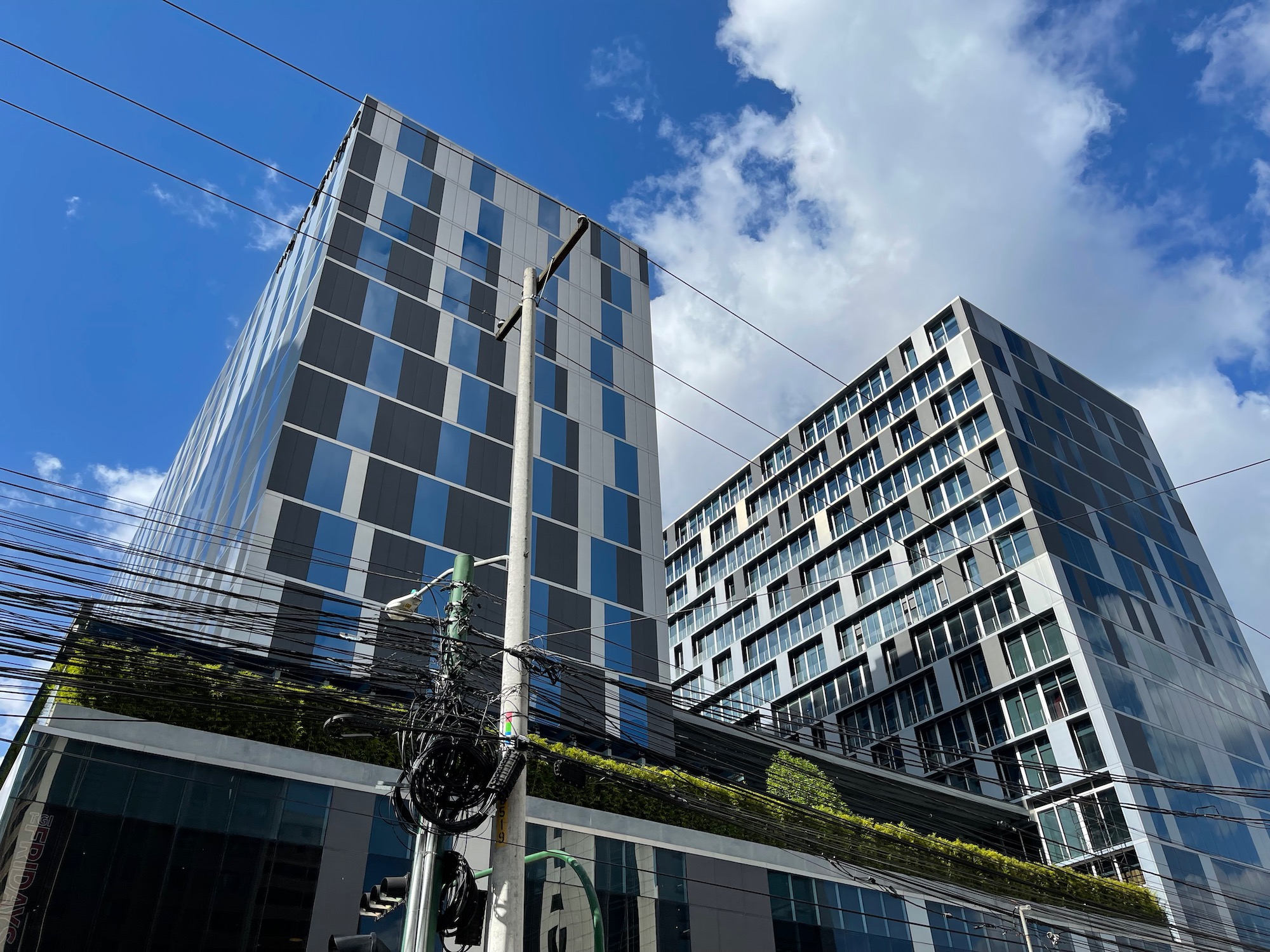 a tall building with power lines and a blue sky