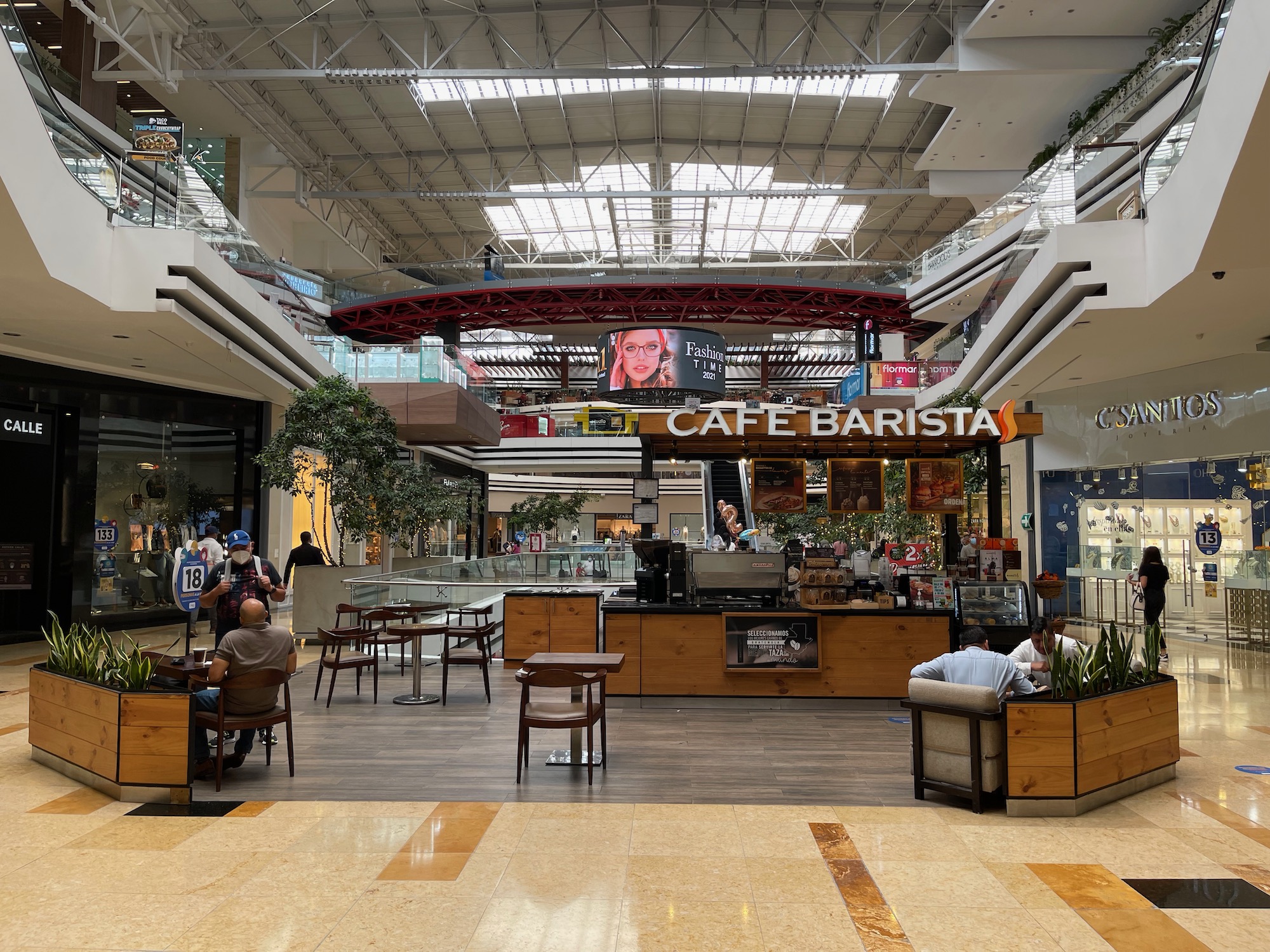 a large building with a large ceiling and people sitting at tables