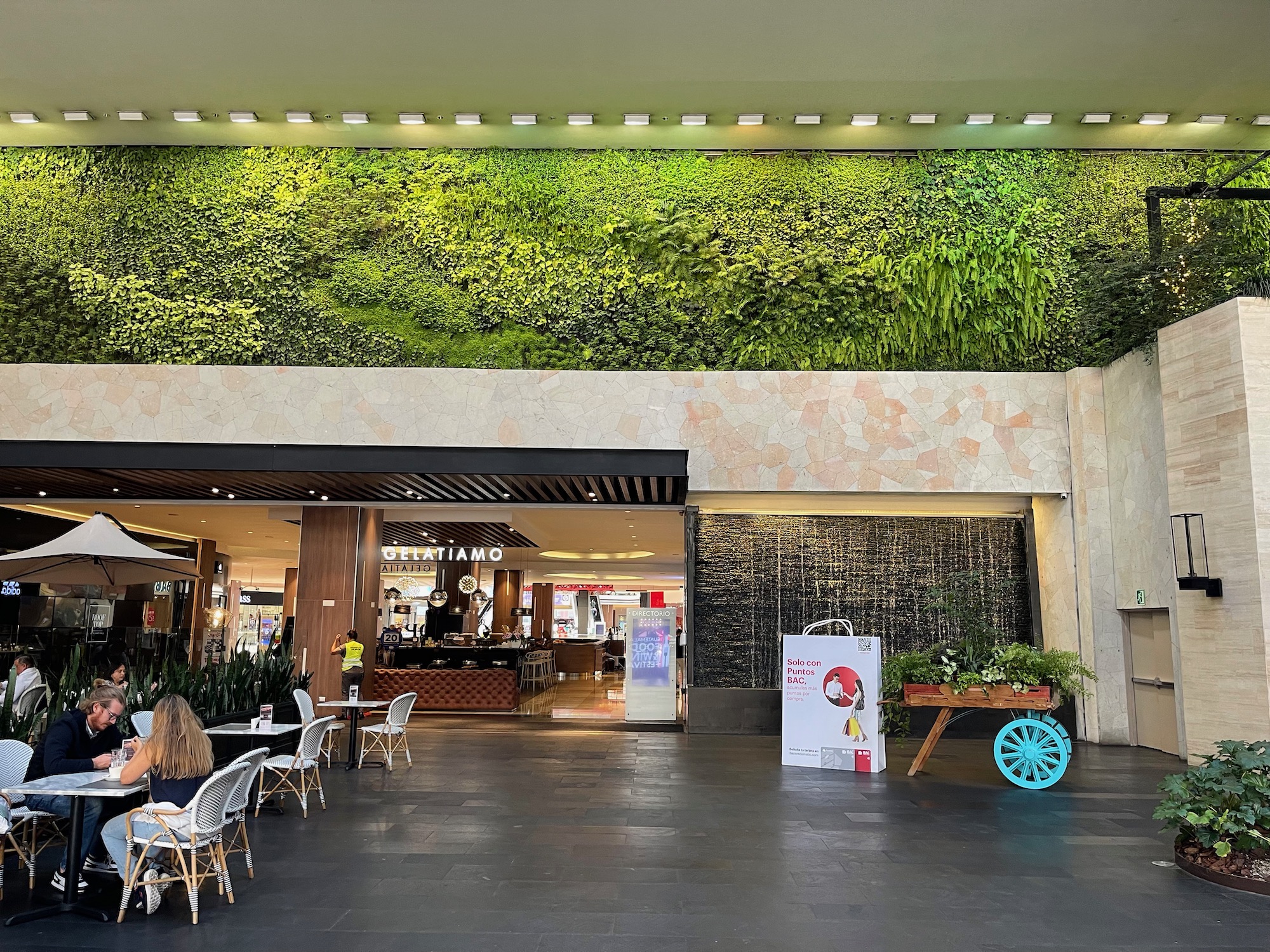 a building with a green wall and plants on the ceiling