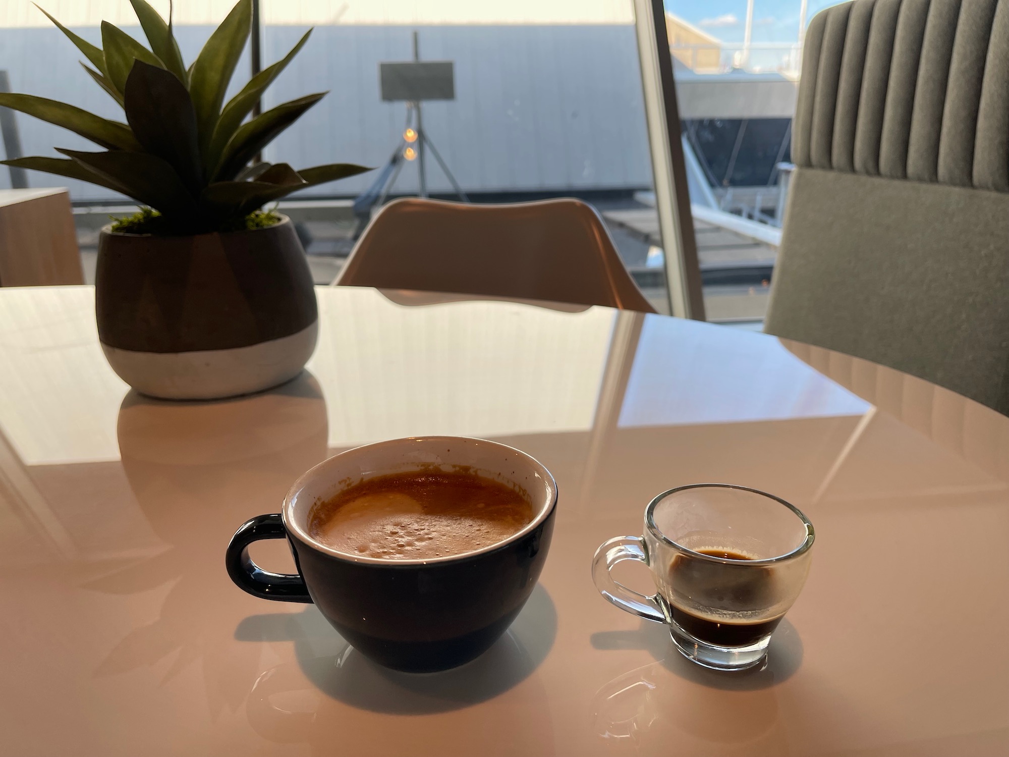 a cup of coffee and a small glass cup of coffee on a table