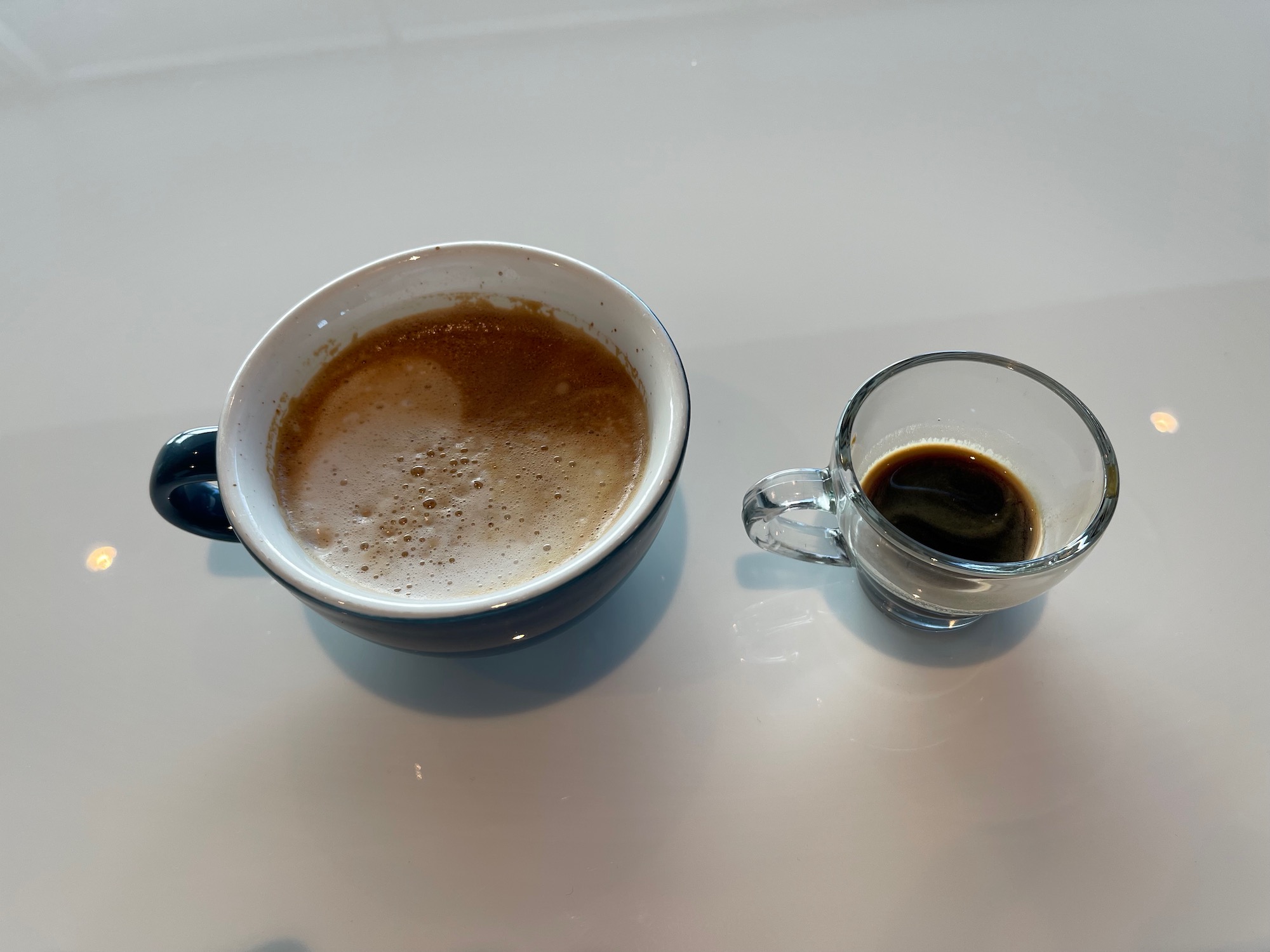 a cup of coffee and a small glass of coffee