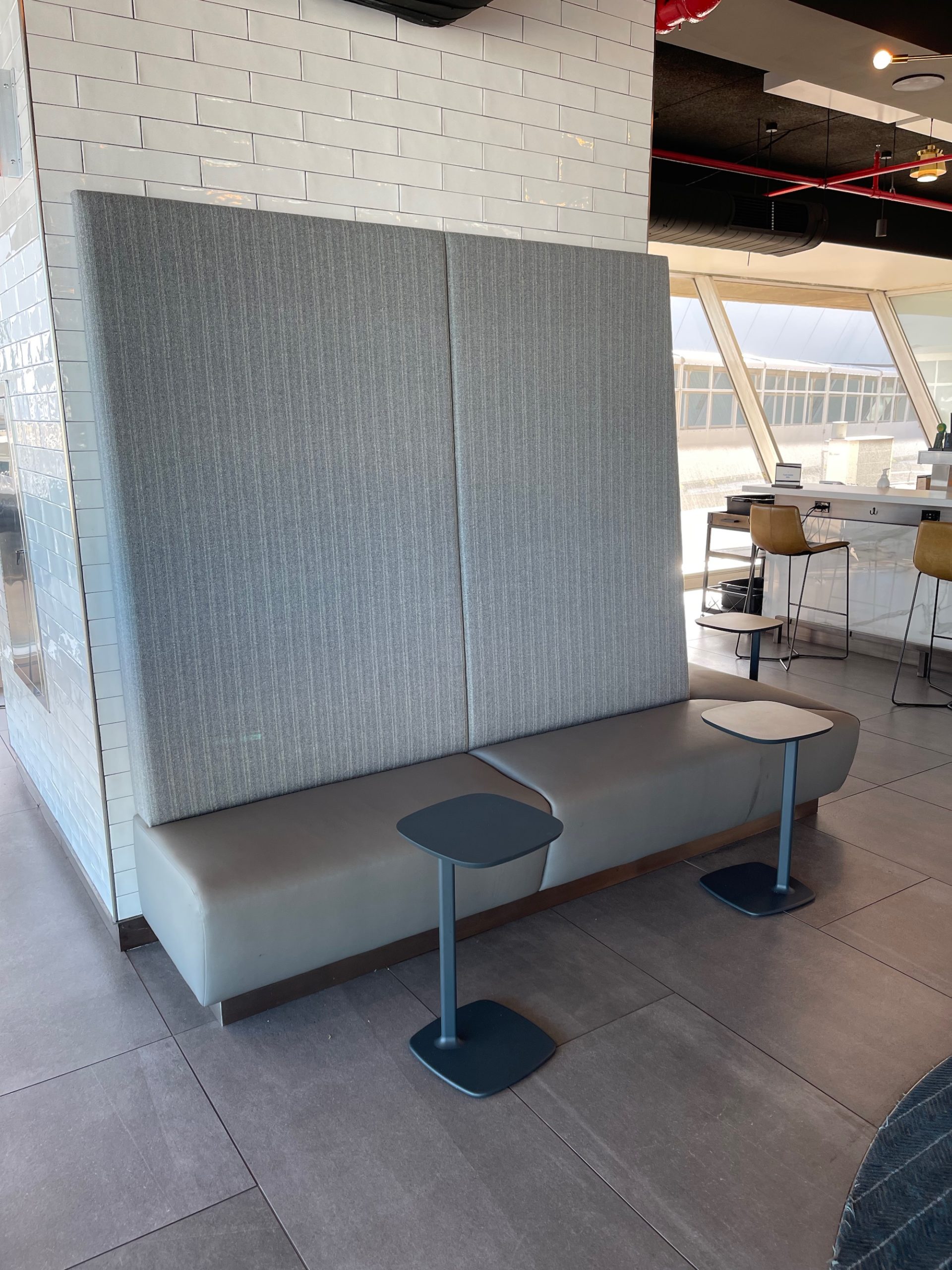 a grey booth with two stools