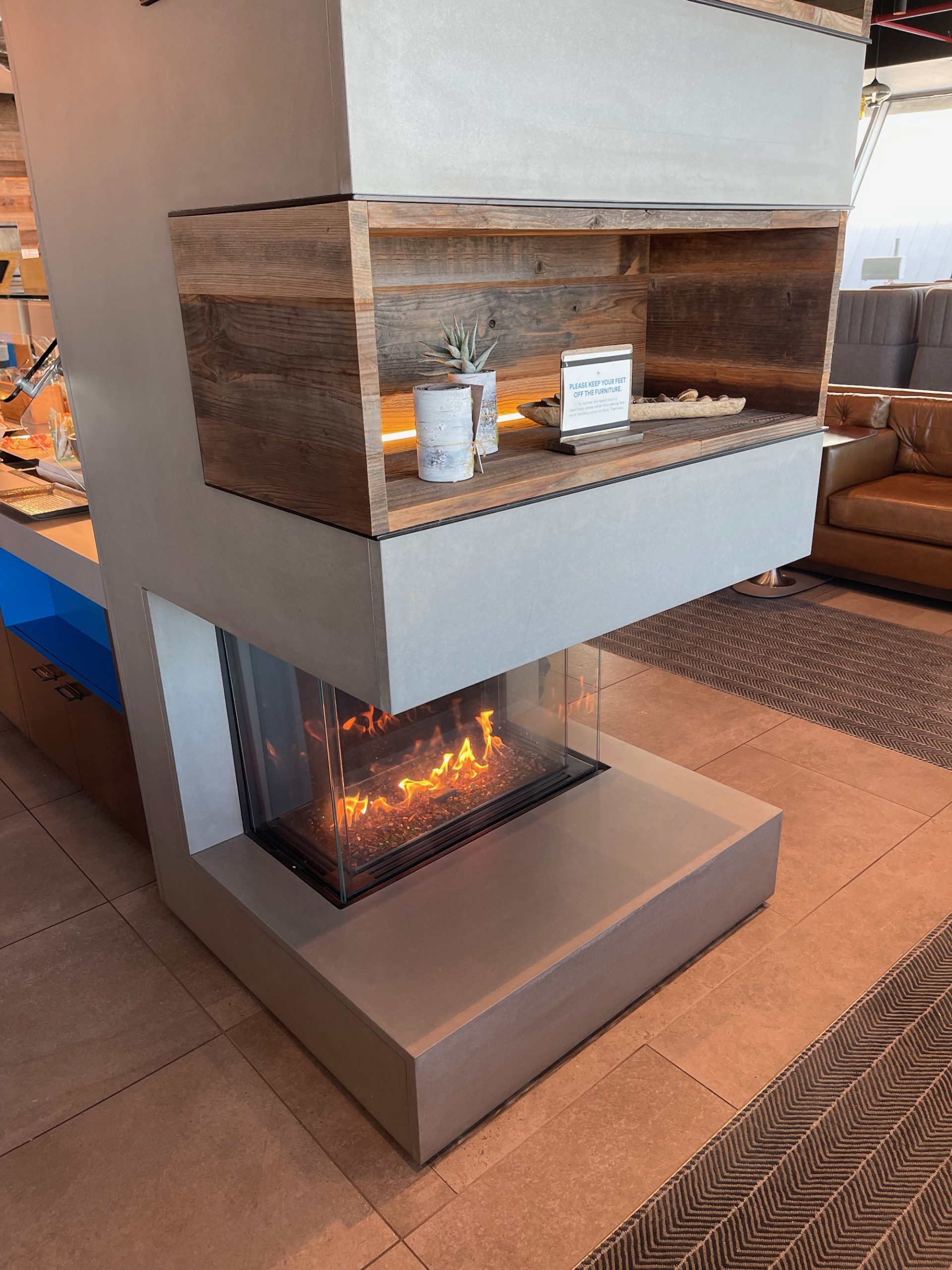 a fireplace with a wood shelf and a plant on top