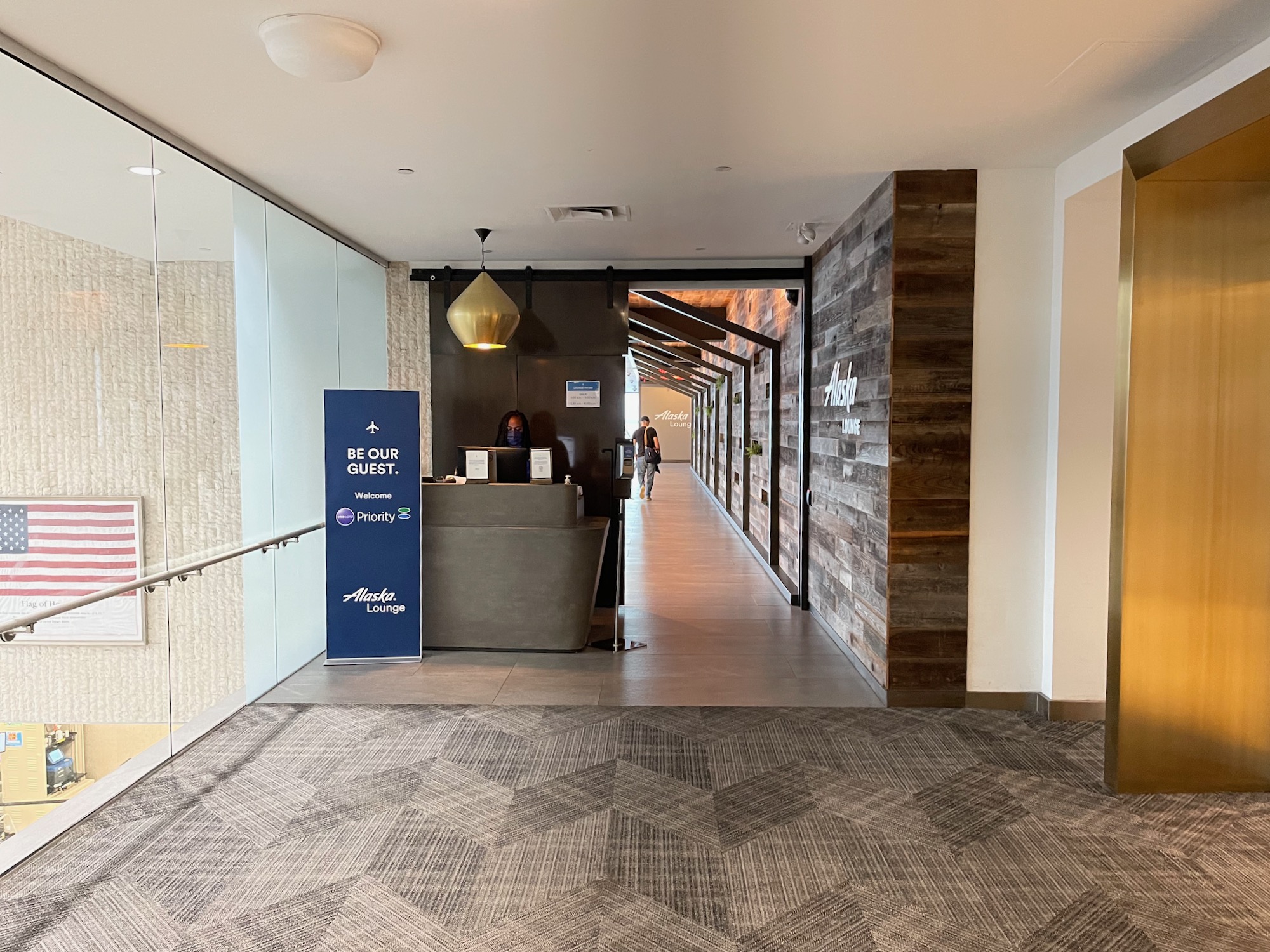 a hallway with a reception desk and a person walking