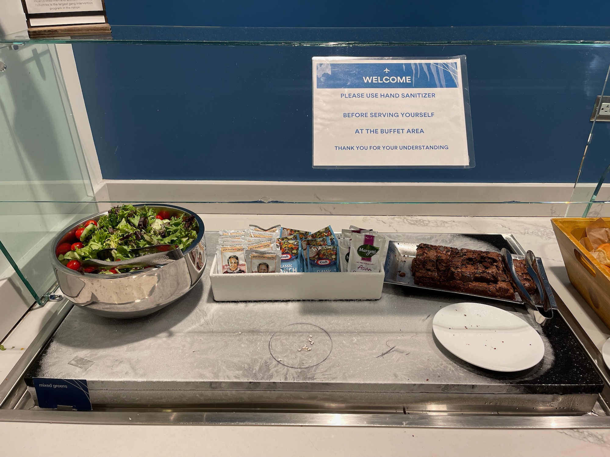 a salad bowl and a plate of brownies on a counter