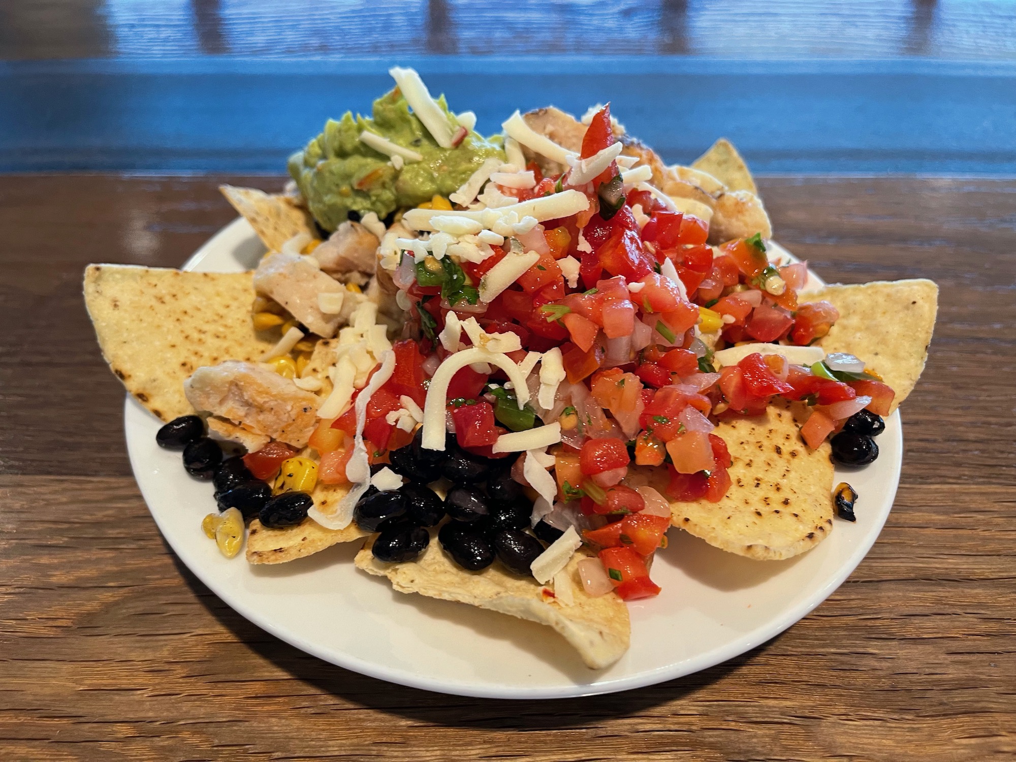 a plate of nachos with salsa guacamole and cheese