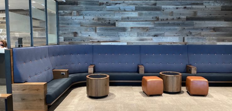 a blue couch with wooden stools in a room