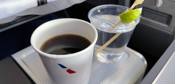 a cup of coffee and a glass of water on a tray