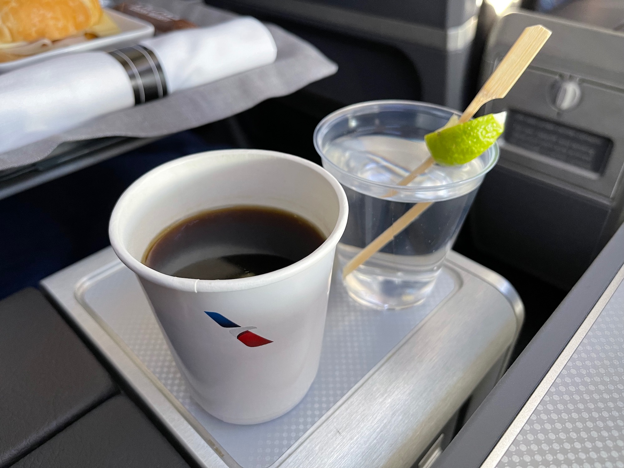 a cup of coffee and a glass of water on a tray