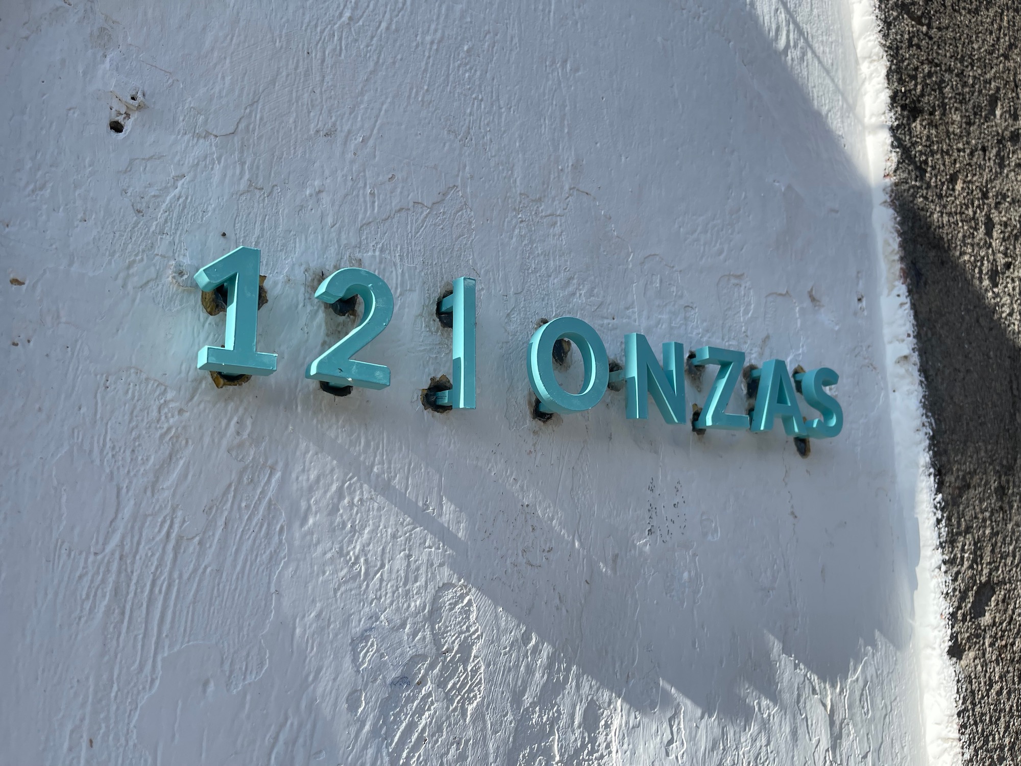 a blue address sign on a white wall