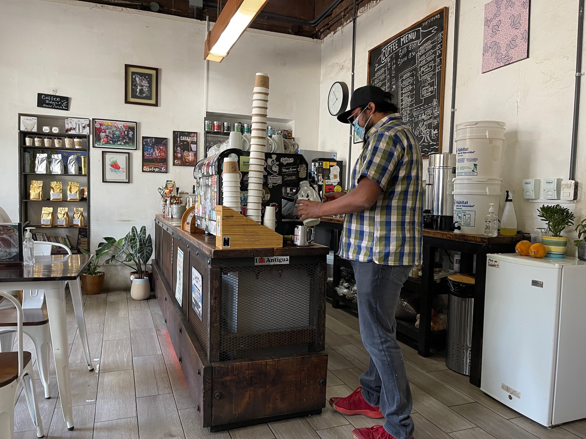 a man wearing a face mask standing in a coffee shop