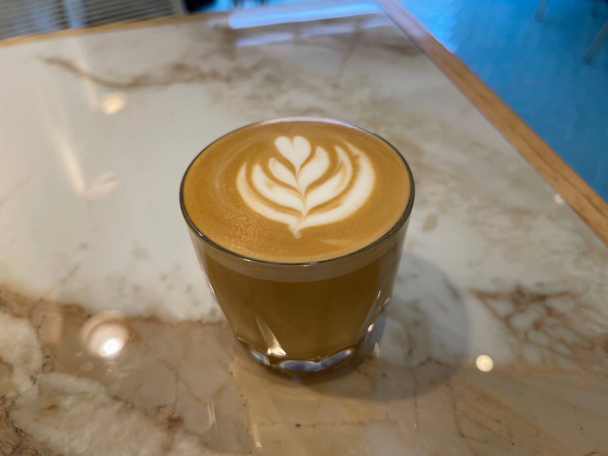 a glass of coffee with a leaf design on top