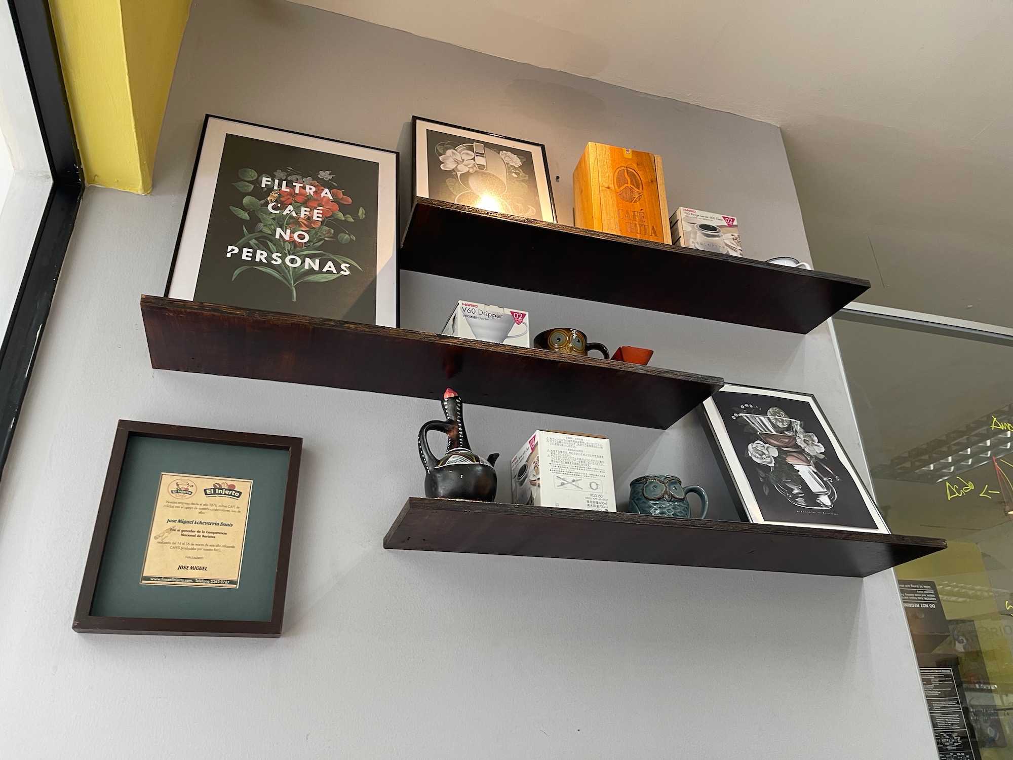 a shelf with pictures and a teapot on it