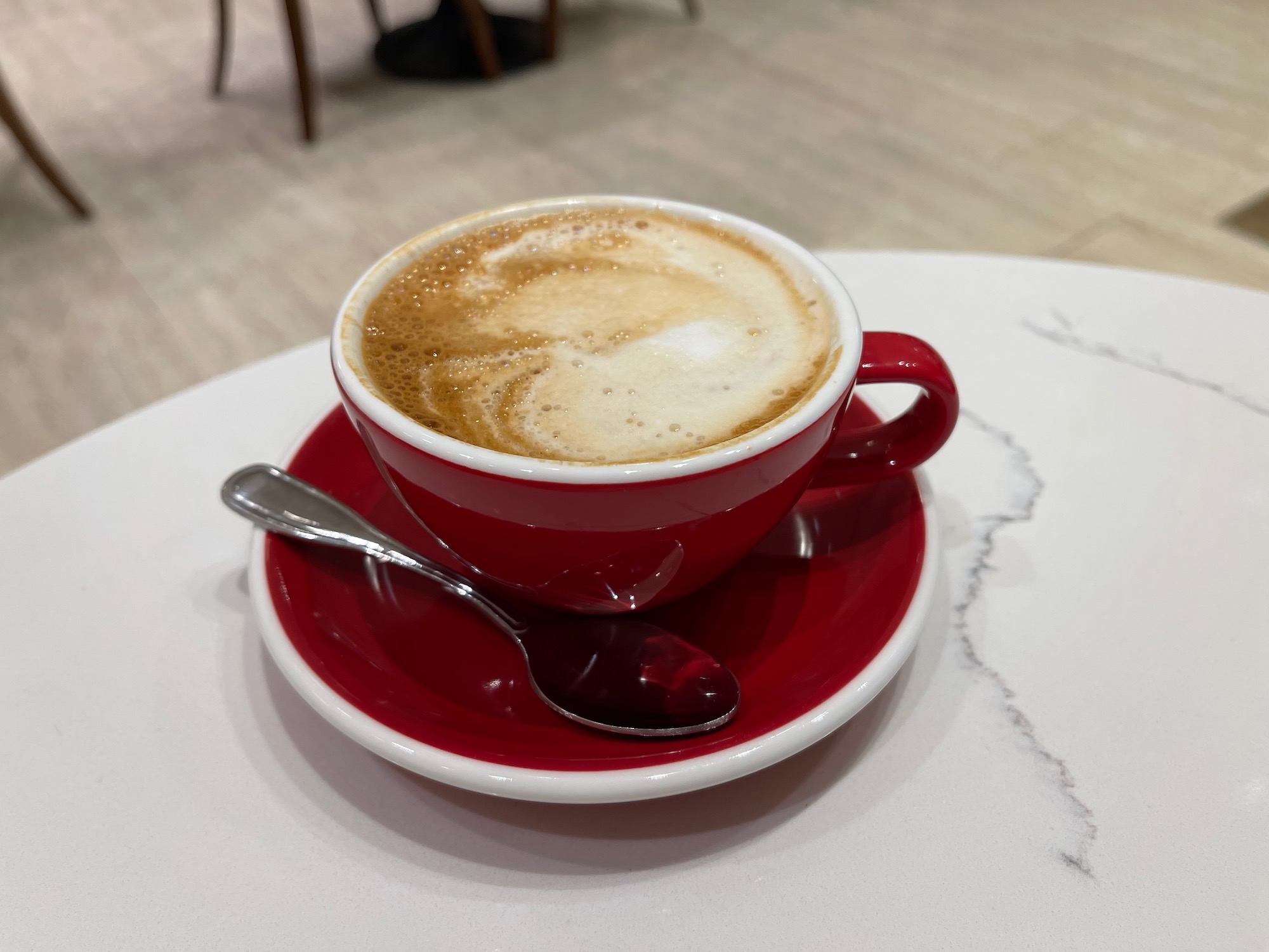 a red cup with a spoon and a foamy drink