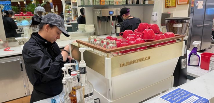 a man standing behind a counter with red cups