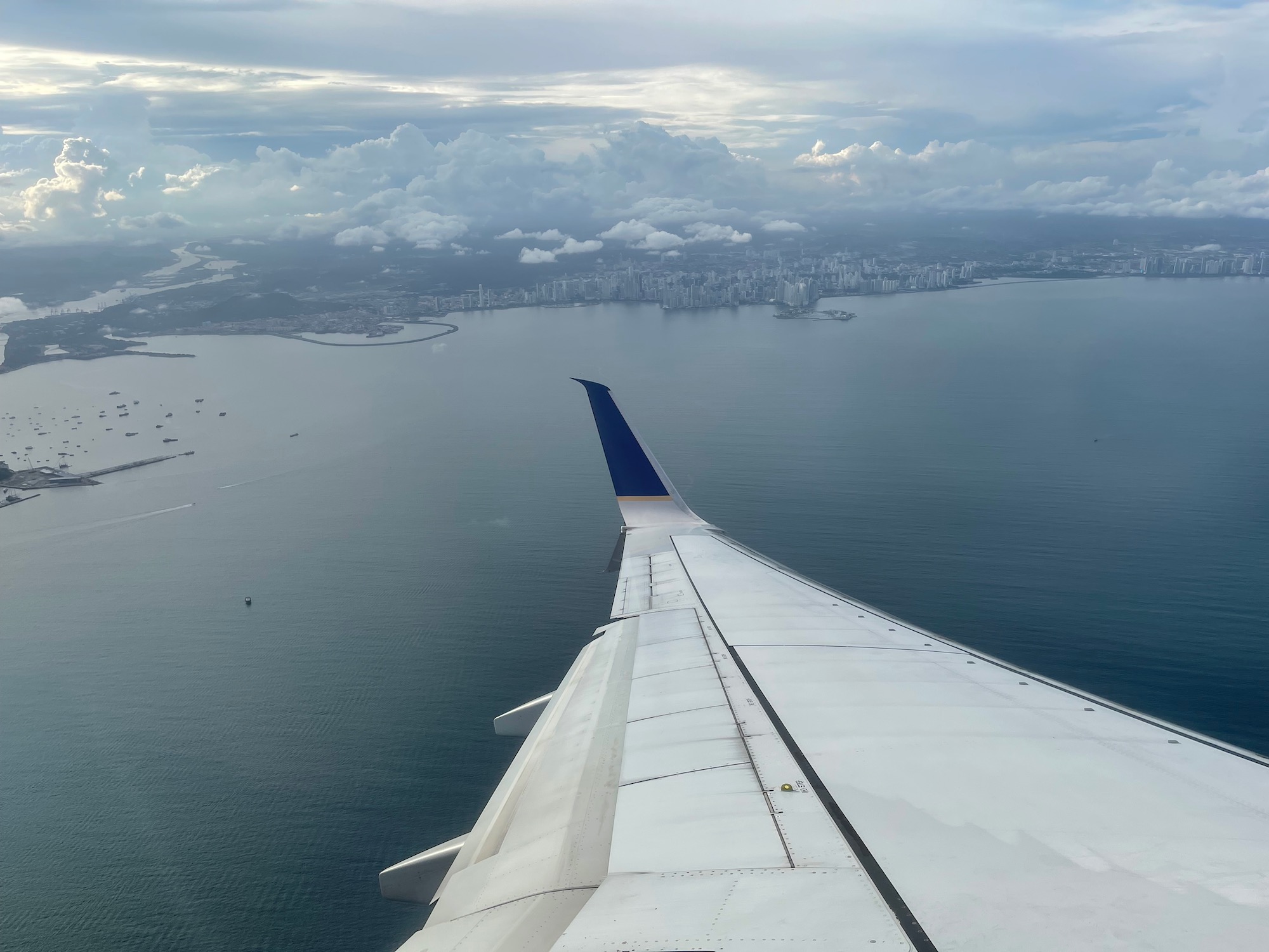 an airplane wing over water and city