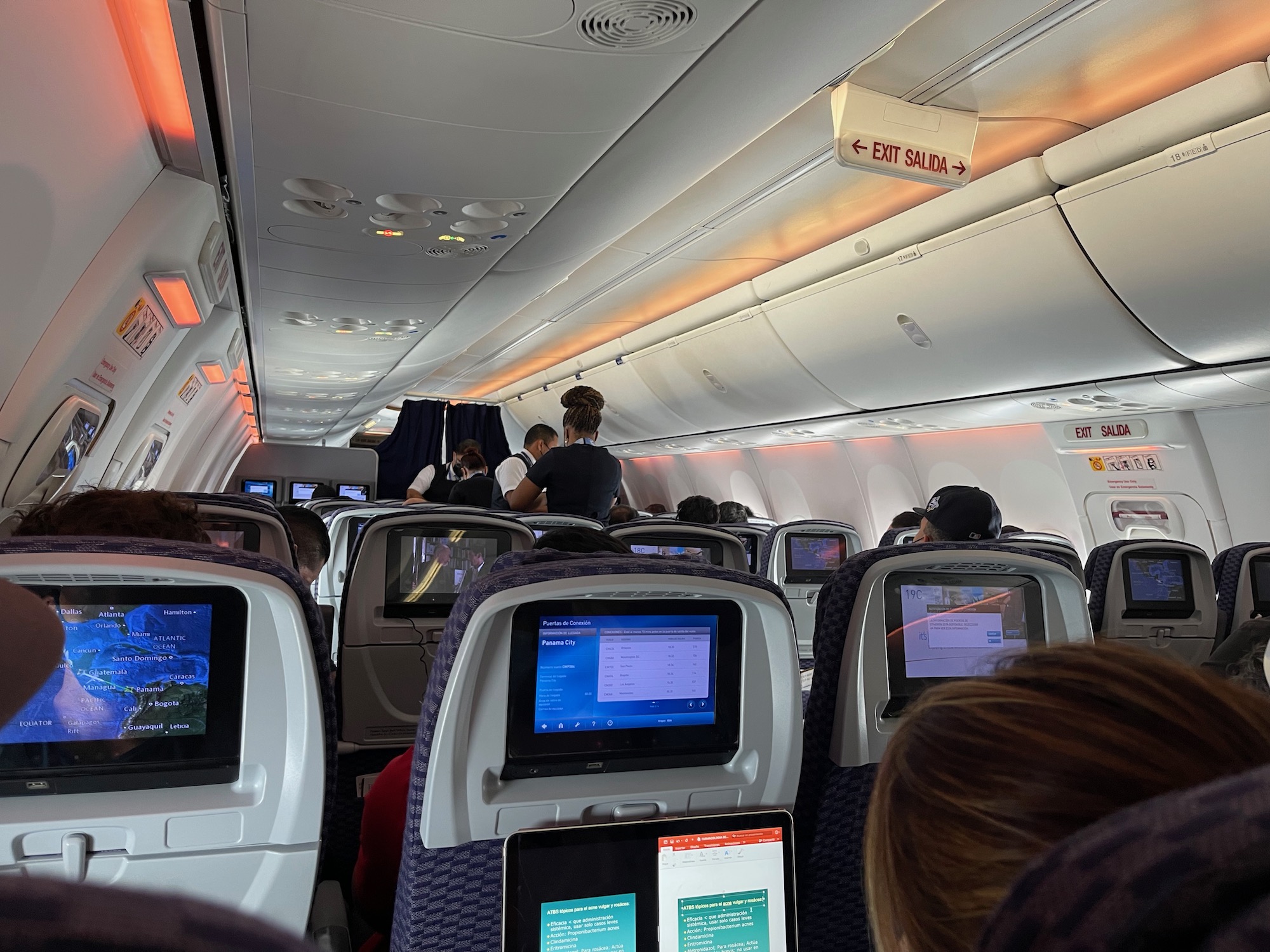 an airplane with many monitors and people sitting on the seats