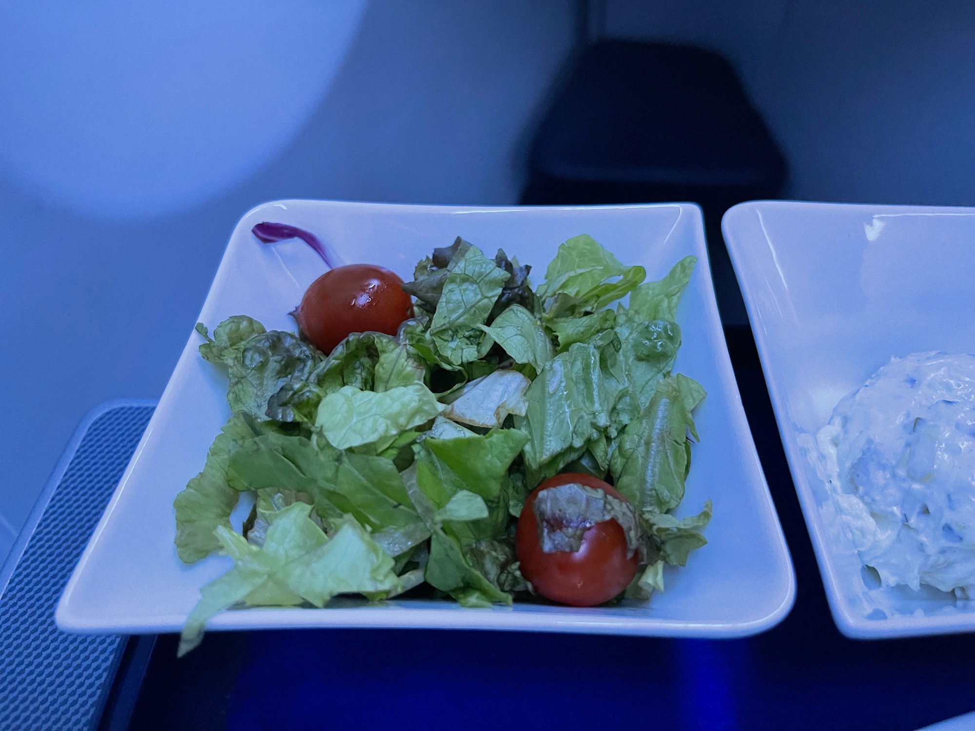 a plate of salad with tomatoes and lettuce