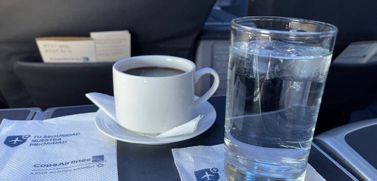 a cup of coffee and a glass of water on a table