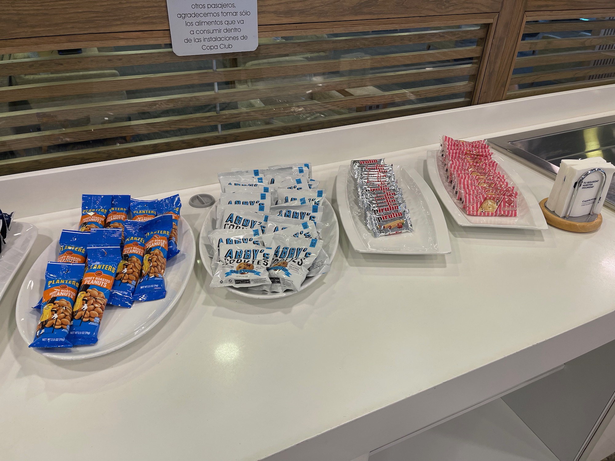 a row of plates of candy and snacks on a counter