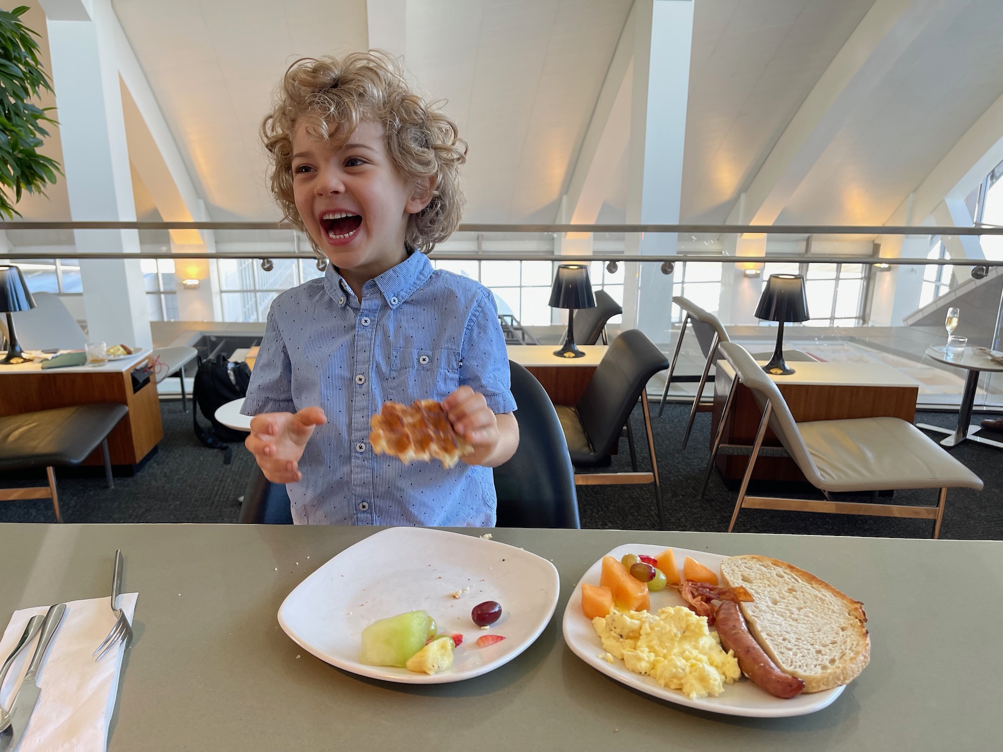 a boy eating breakfast at a table