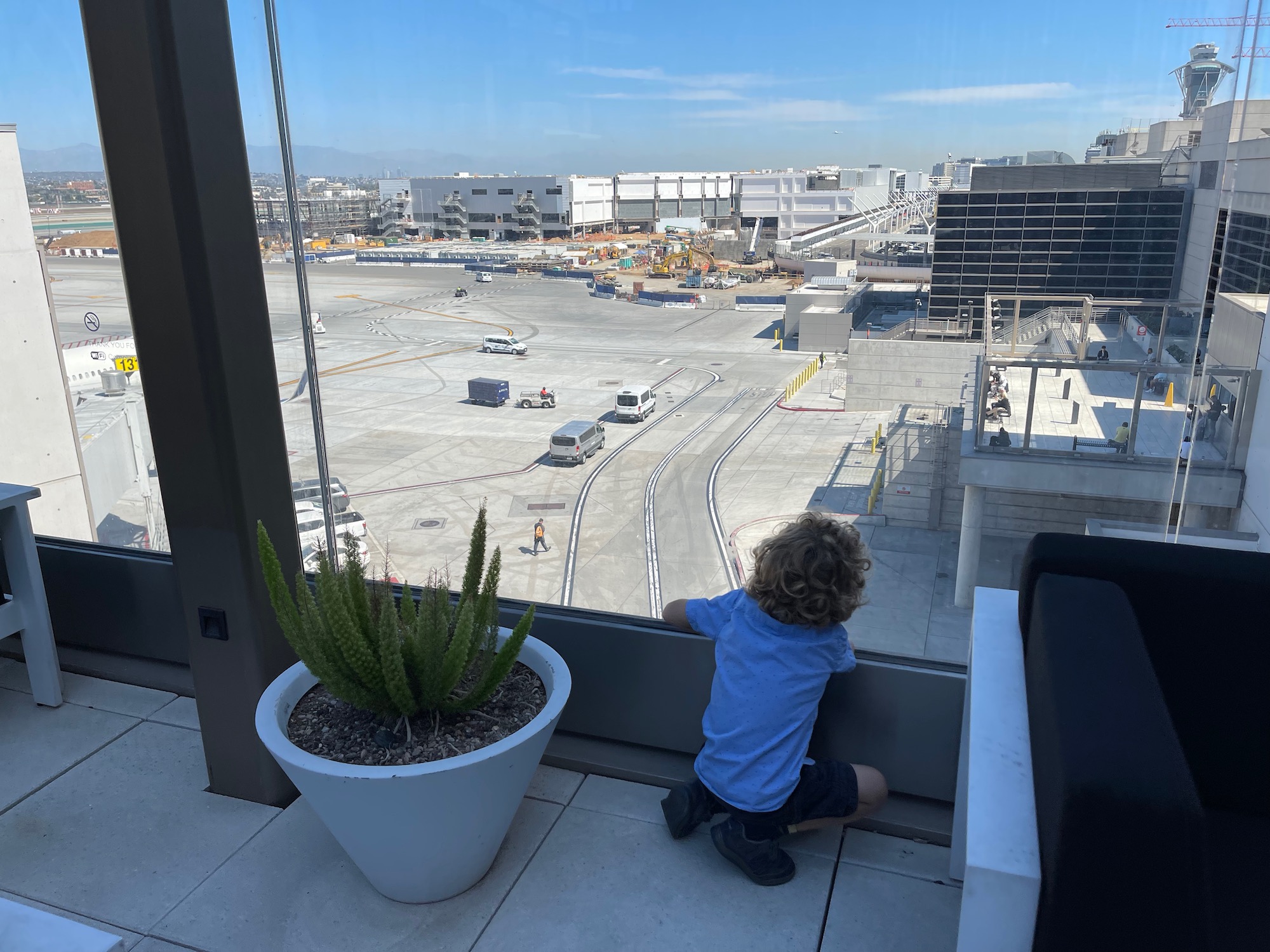 a child looking out a window at an airport