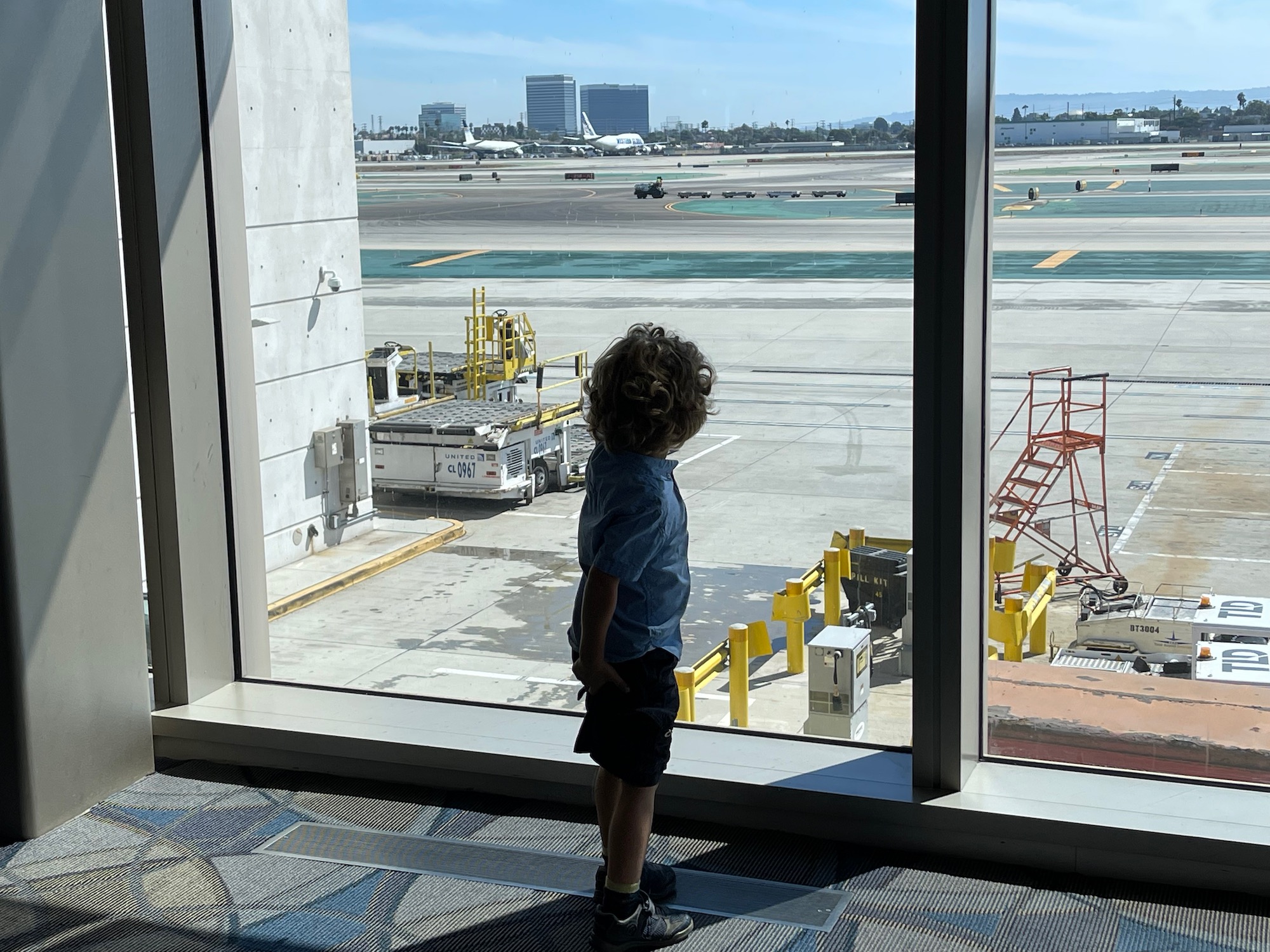 a child looking out a window at an airport