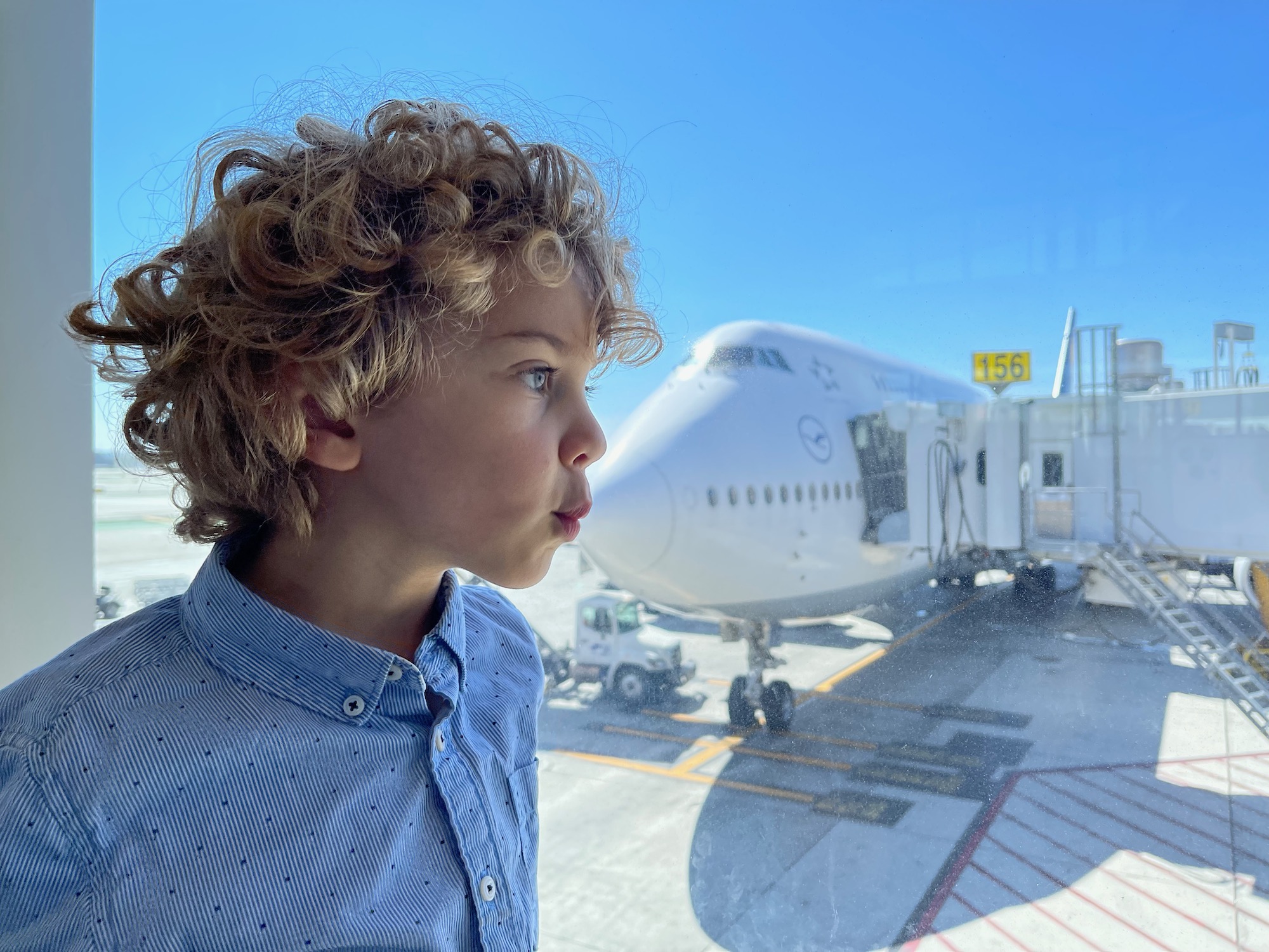 a boy looking out a window at an airplane