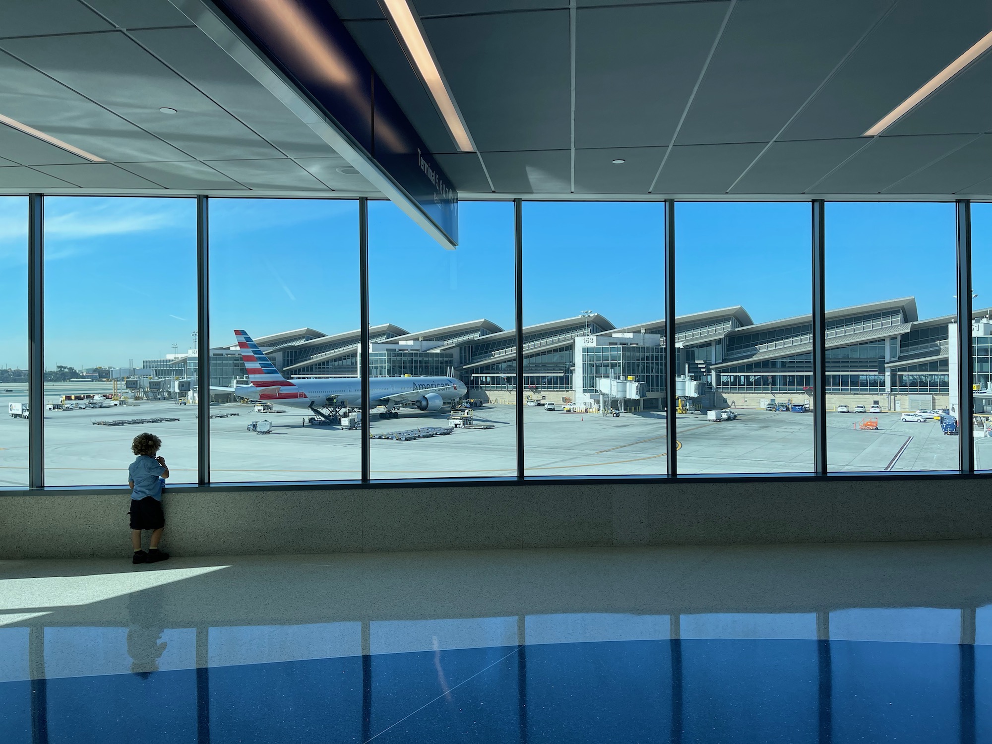 a child looking at an airport window