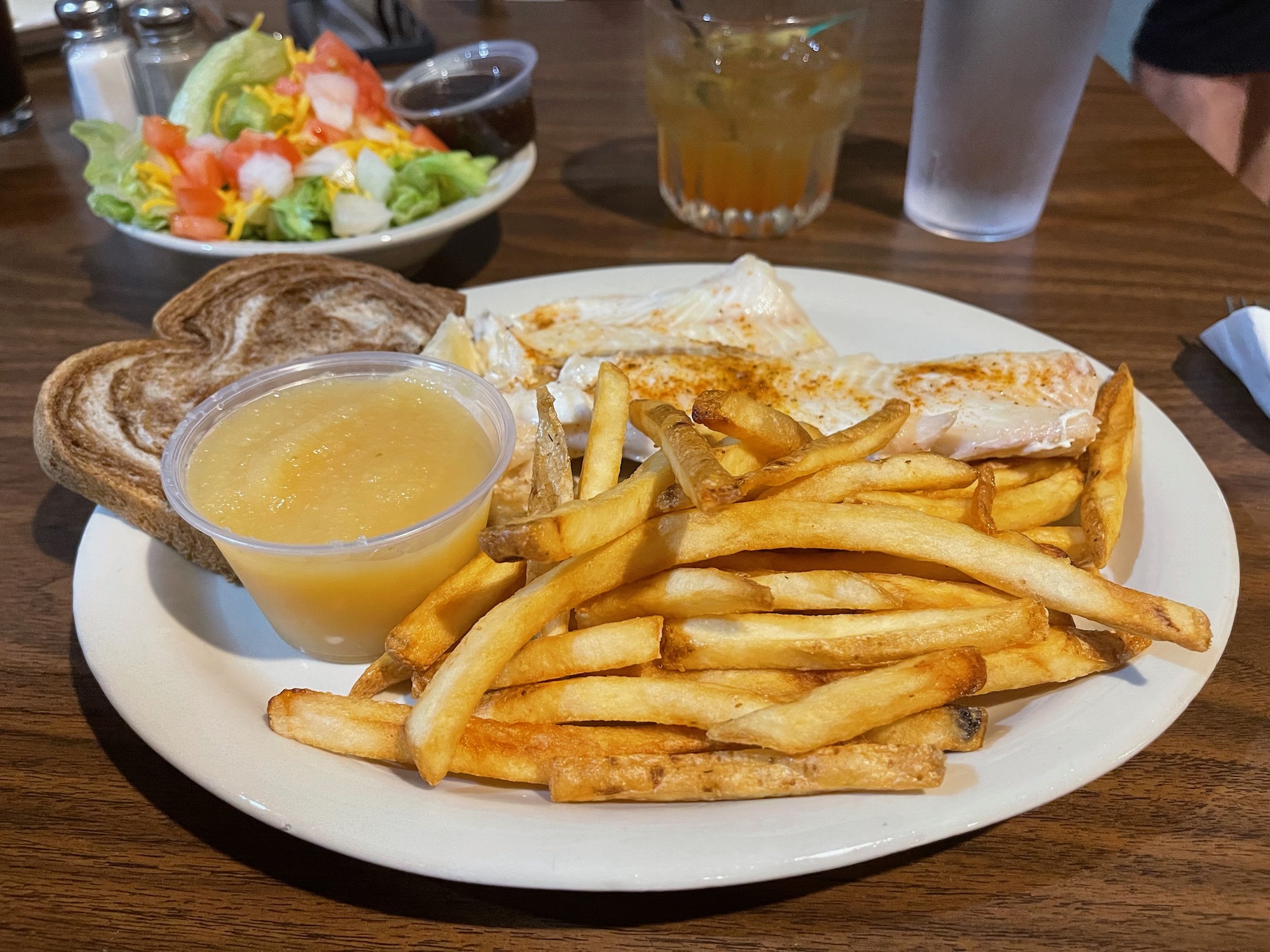 a plate of food with a side of salad and a glass of juice