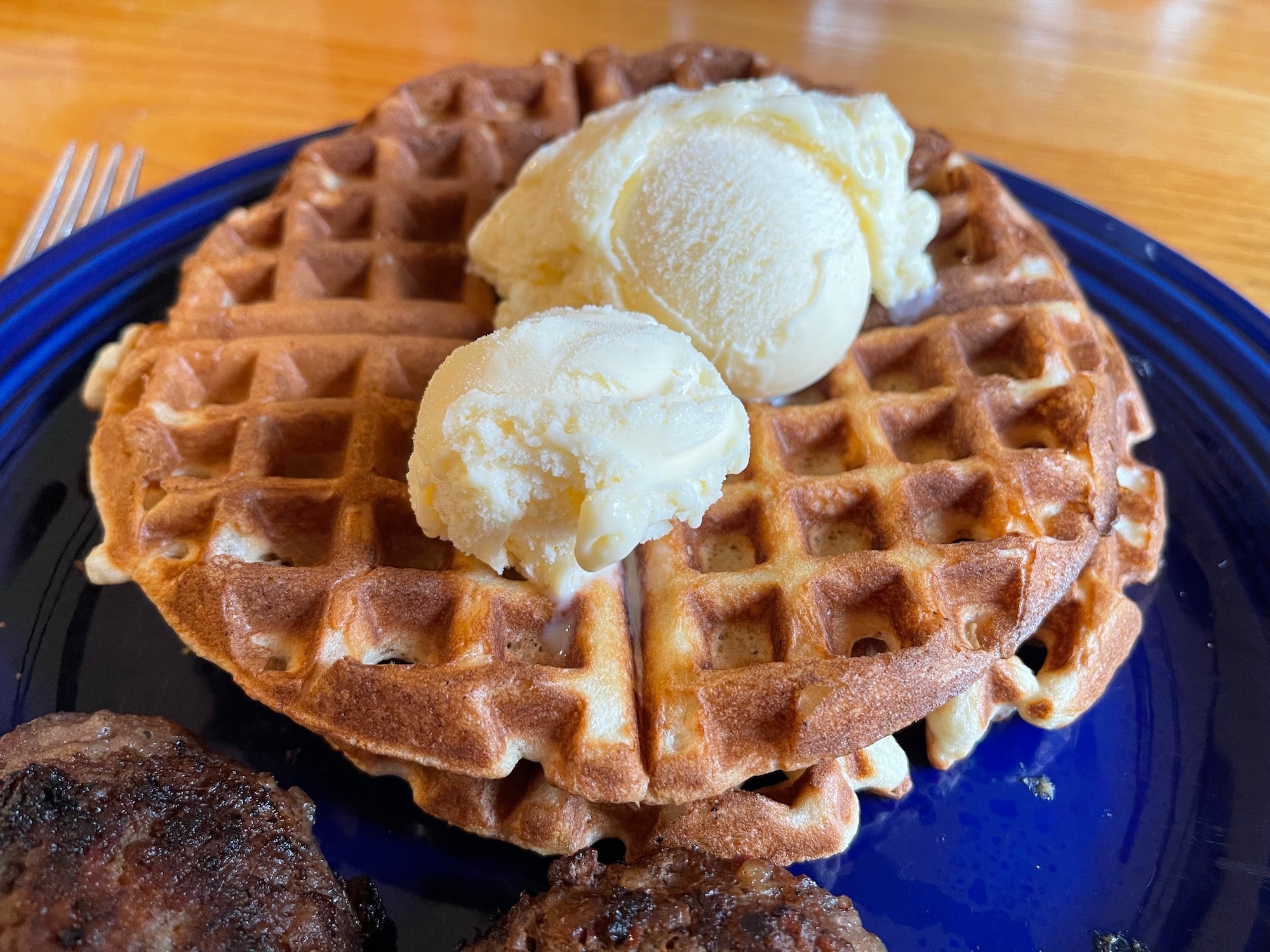 waffles with ice cream on top on a blue plate