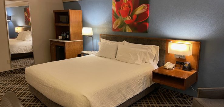 a bed with white sheets and lamps in a hotel room