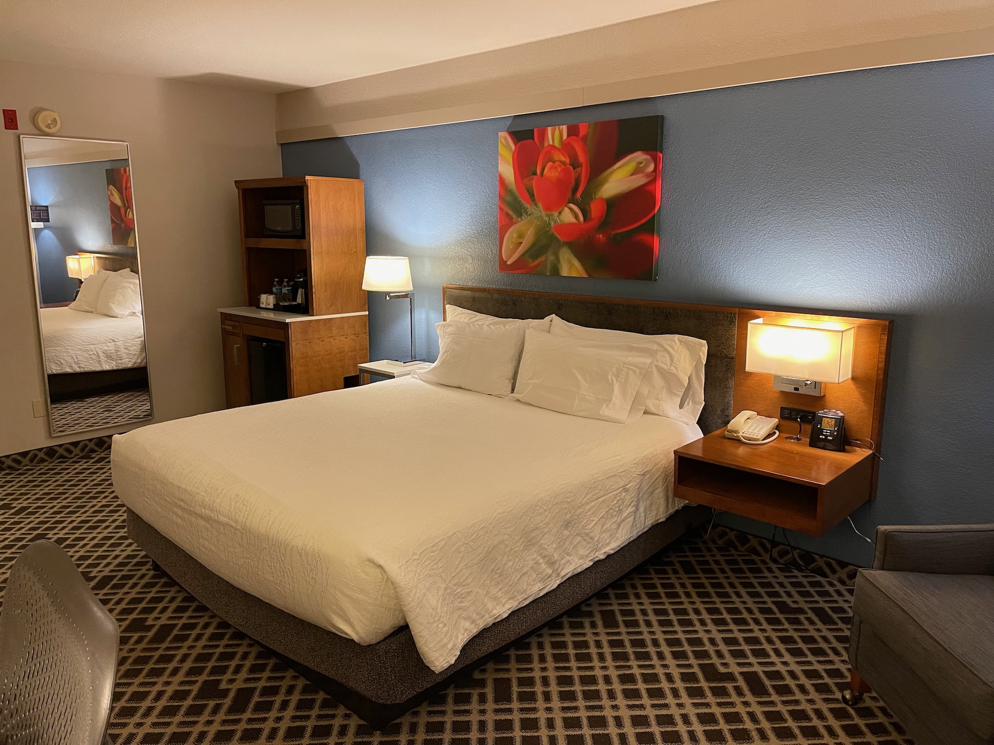 a bed with white sheets and lamps in a hotel room