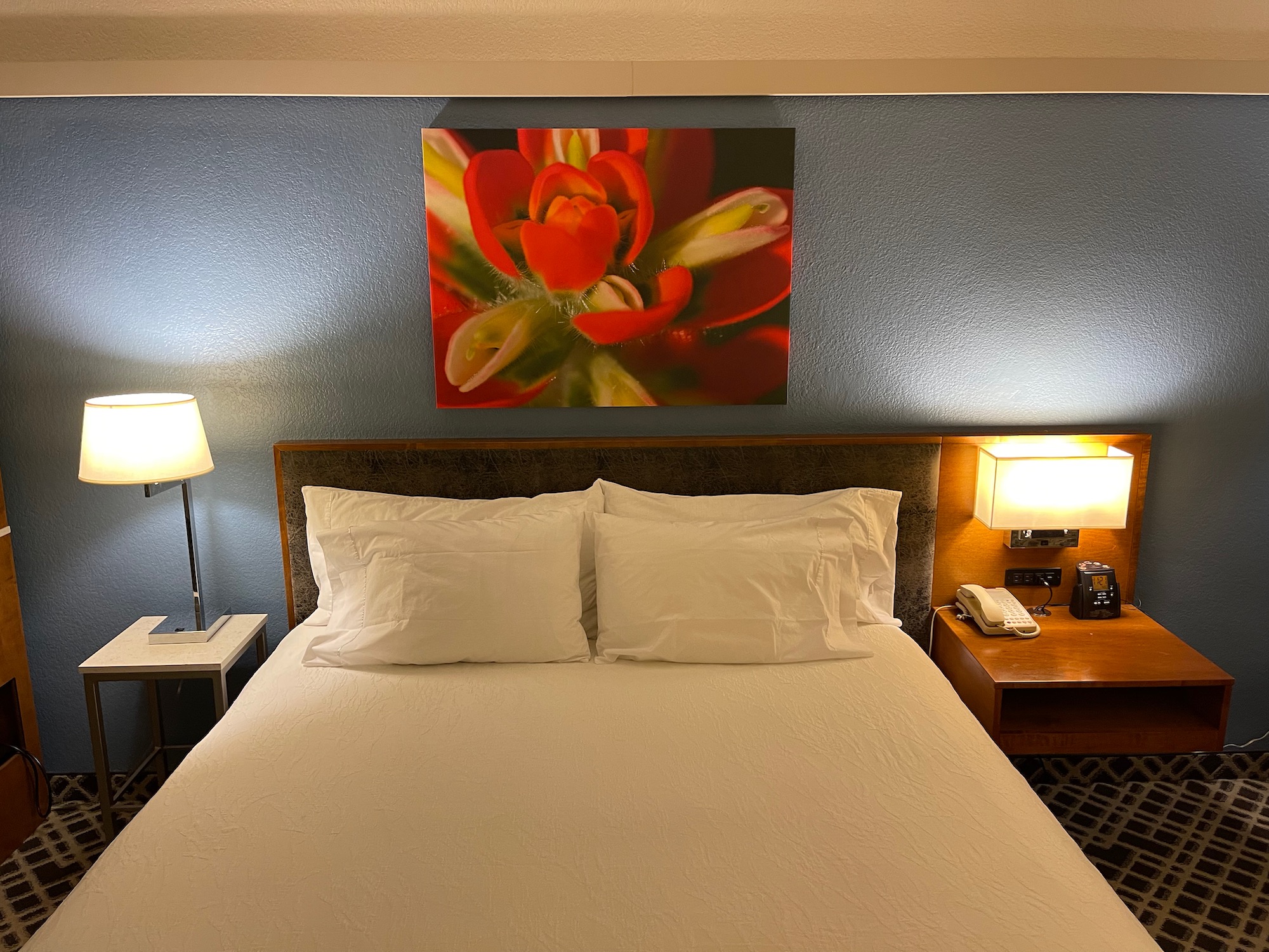 a bed with a painting above it