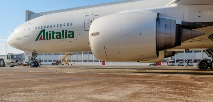 a large white airplane with green writing on it