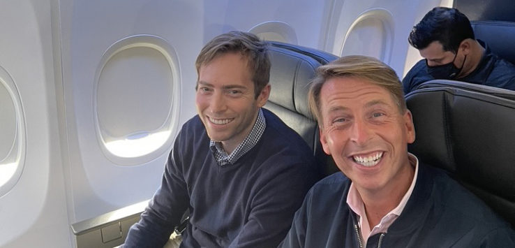 two men sitting in an airplane