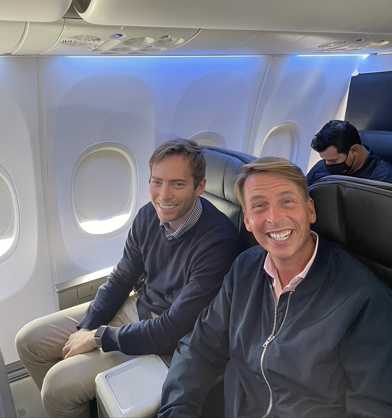 two men sitting in an airplane